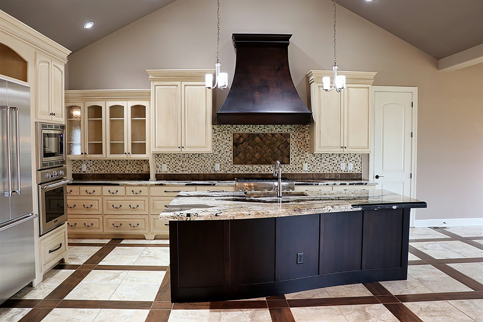 A large island with thick-cut granite countertop offsets the kitchen from the great room. The island has bar seating for up to six and has a built-in sink and dishwasher. Amish-handcrafted cabinets fill one wall with some glass-front cabinet doors. CONTRIBUTED PHOTO BY KATHY TYLER