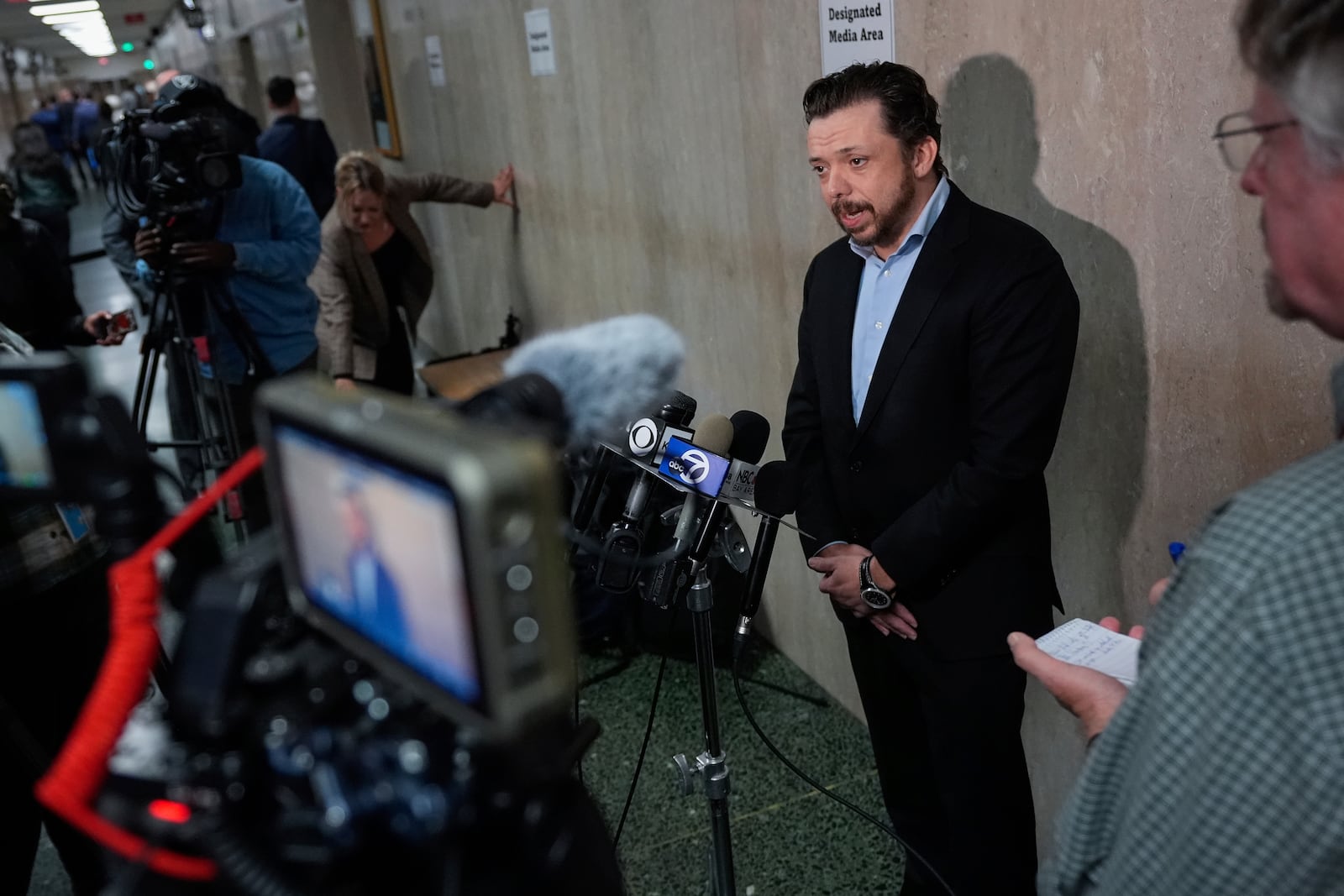 Timothy Oliver Lee, second from right, brother of Cash App founder Bob Lee, speaks to reporters after exiting the courtroom at the Hall of Justice for the murder trial of Nima Momeni, Tuesday, Dec. 3, 2024, in San Francisco. (AP Photo/Godofredo A. Vásquez)