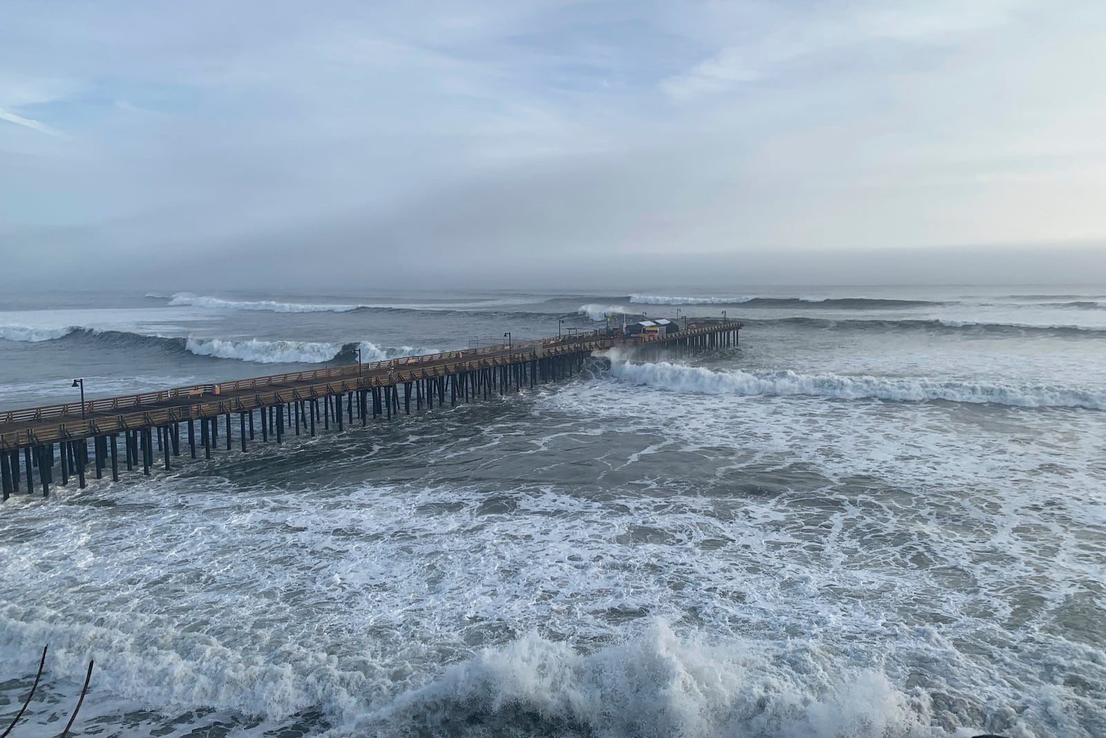 High surf rolls past the Capitola Wharf, Monday, Dec. 23, 2024, in Capitola, Calif. (AP Photo/Pamela Hassell)