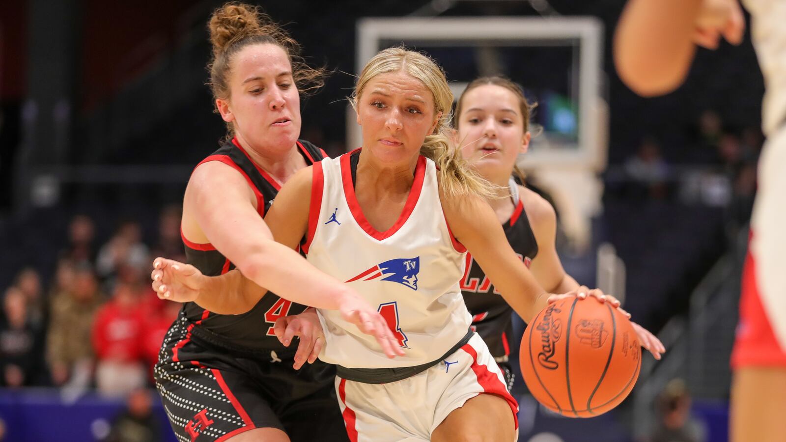 Tri-Village High School senior Rylee Sagester drives past Berlin Hiland senior Abby Miller during a Division IV state semifinal game on Thursday night at University of Dayton Arena. The senior scored a game-high 22 points as the Patriots advanced to the state final for the first time in program history, beating the Hawks 51-34. CONTRIBUTED PHOTO BY MICHAEL COOPER