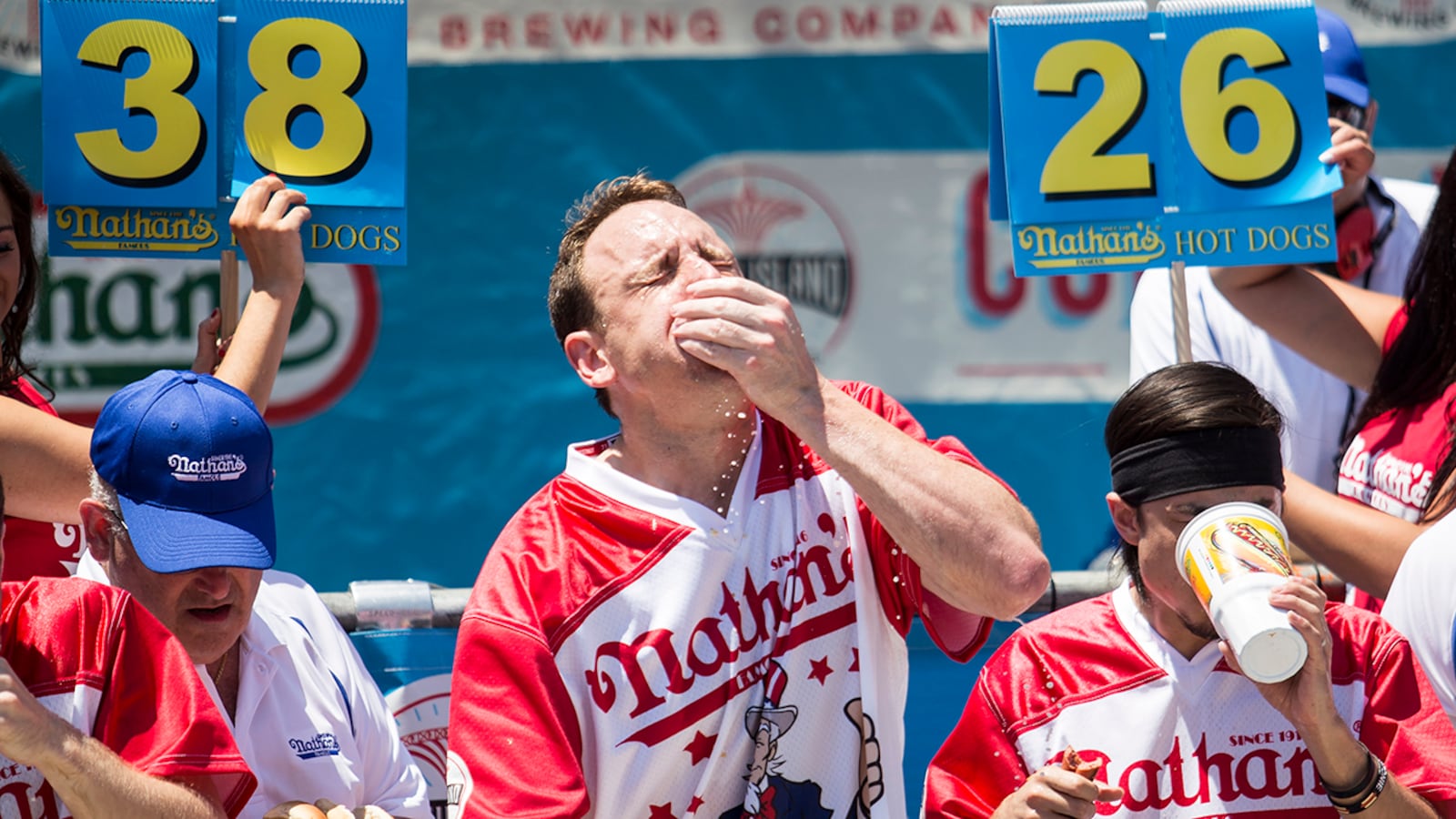 Joey Chestnut (C) and Matt Stonie (R) compete in the 2017 Nathan's Famous International Hot Dog Eating Contest at Coney Island on July 4, 2017 in the Brooklyn borough of New York City. Chestnut was declared the winner for this 10th title overall after eating 72 hot dogs in 10 minutes. The contest in Coney Island is in it's 101th year. (Photo by Alex Wroblewski/Getty Images)