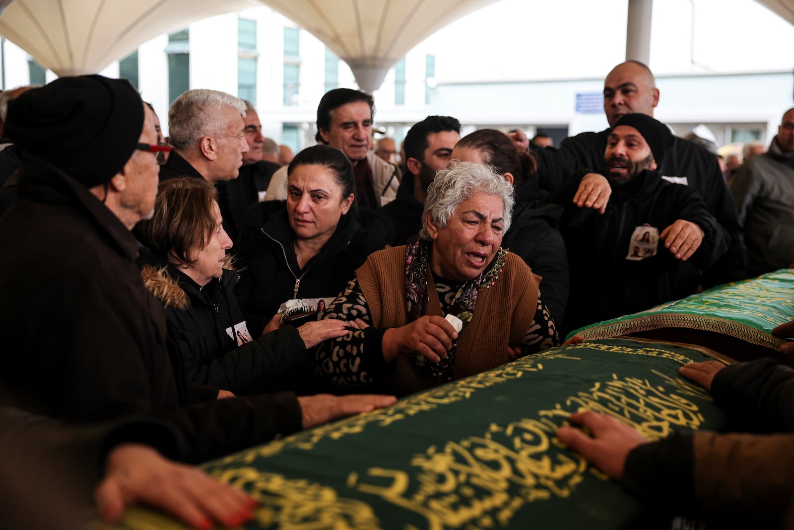 Relatives and friends mourn during the funeral of Yilmaz Saritas and his children Nehir and Doruk, who were among the 76 victims who died in a fire at the Kartalkaya ski resort in Bolu province, at Karsıyaka cemetery in Ankara, Wednesday, Jan. 22, 2025. (Ugur Yildirim/Dia Photo via AP)