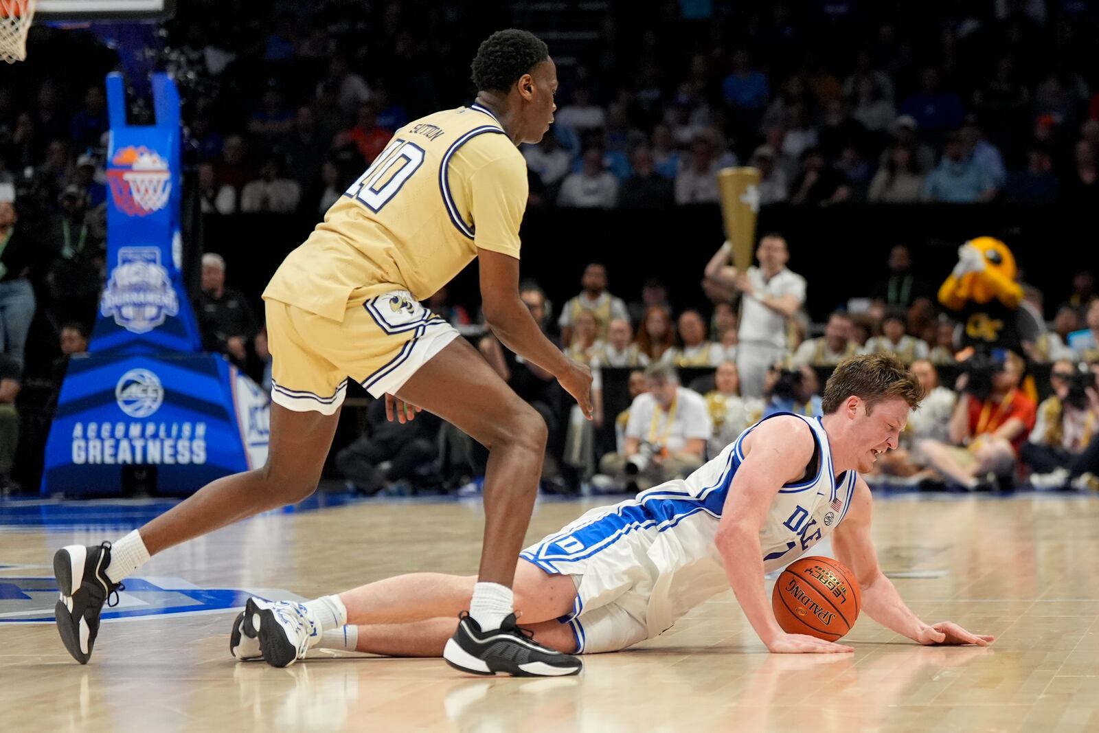 Duke guard Kon Knueppel dives for the ball past Georgia Tech forward Darrion Sutton during the second half of an NCAA college basketball game in the quarterfinals of the Atlantic Coast Conference tournament, Thursday, March 13, 2025, in Charlotte, N.C. (AP Photo/Chris Carlson)