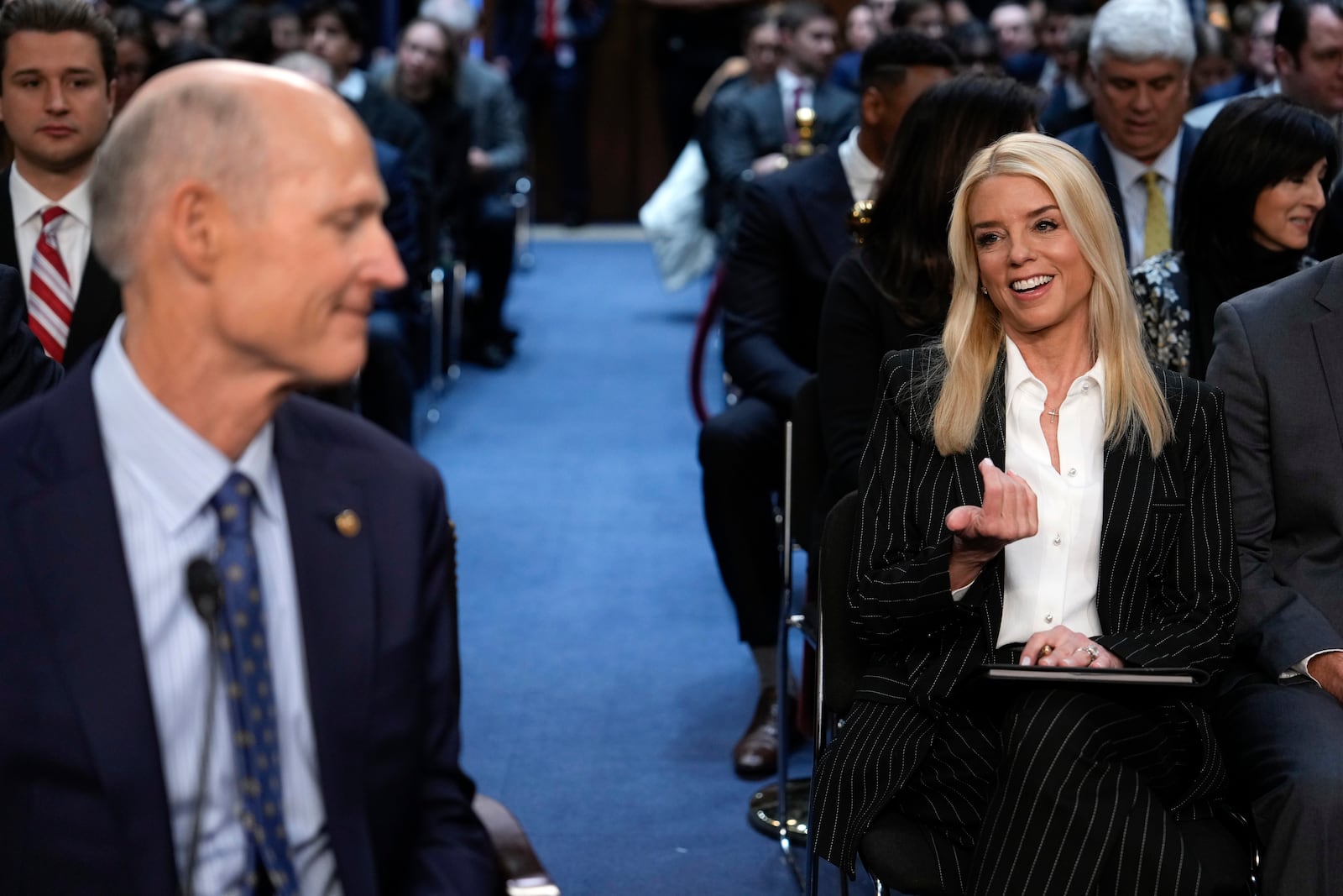 Pam Bondi, right, President-elect Donald Trump's choice to lead the Justice Department as attorney general, speaks with Sen. Rick Scott, R-Fla., left, before the Senate Judiciary Committee for her confirmation hearing, at the Capitol in Washington, Wednesday, Jan. 15, 2025. (AP Photo/Ben Curtis)