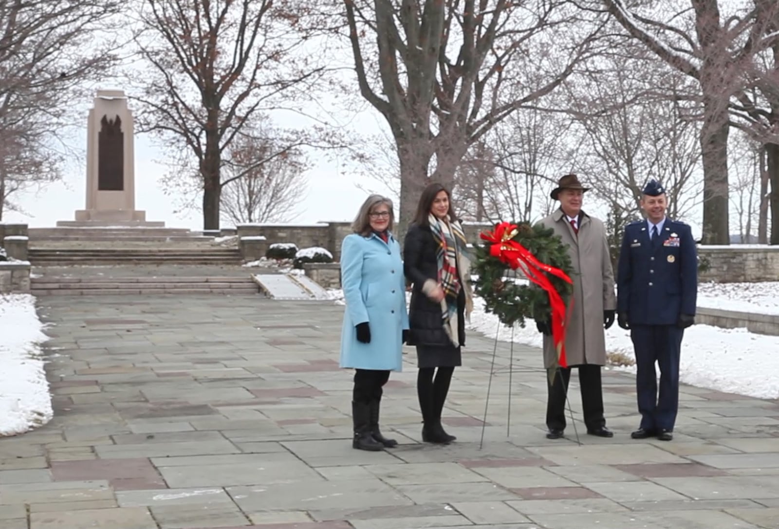 A wreath laying commemorating the 113th Anniversary of the Wright Brothers First Powered Flight took place at Wright Memorial Hill on Friday.  Most of the ceremony took place inside of the Huffman Prairie Flying Field Interpretive Center due to the bitter cold, but participants got outside to place the wreath just in time for a flying salute to the Wrights. Wright family members Amanda Wright-Lane, Iris Lane and her father Stephen Wright placed a wreath at the Wright Brothers Memorial with Wright-Patterson Air Force Base 88th Air Base Wing Commander Col. Bradley M. McDonald.  Within seconds, the roar of a perfectly timed flyover by a WWII era P-51D Mustang followed, marking the hour and minute of the first flight: 10:35 a.m.   "It's a snowy, cloudy backdrop for a beautiful flyover," said Amanda Wight-Lane, Great Grandniece of the Wright Brothers.  The P-51D is part of the Tri-State Warbird Museum in Cincinnati.  TY GREENLEES / STAFF