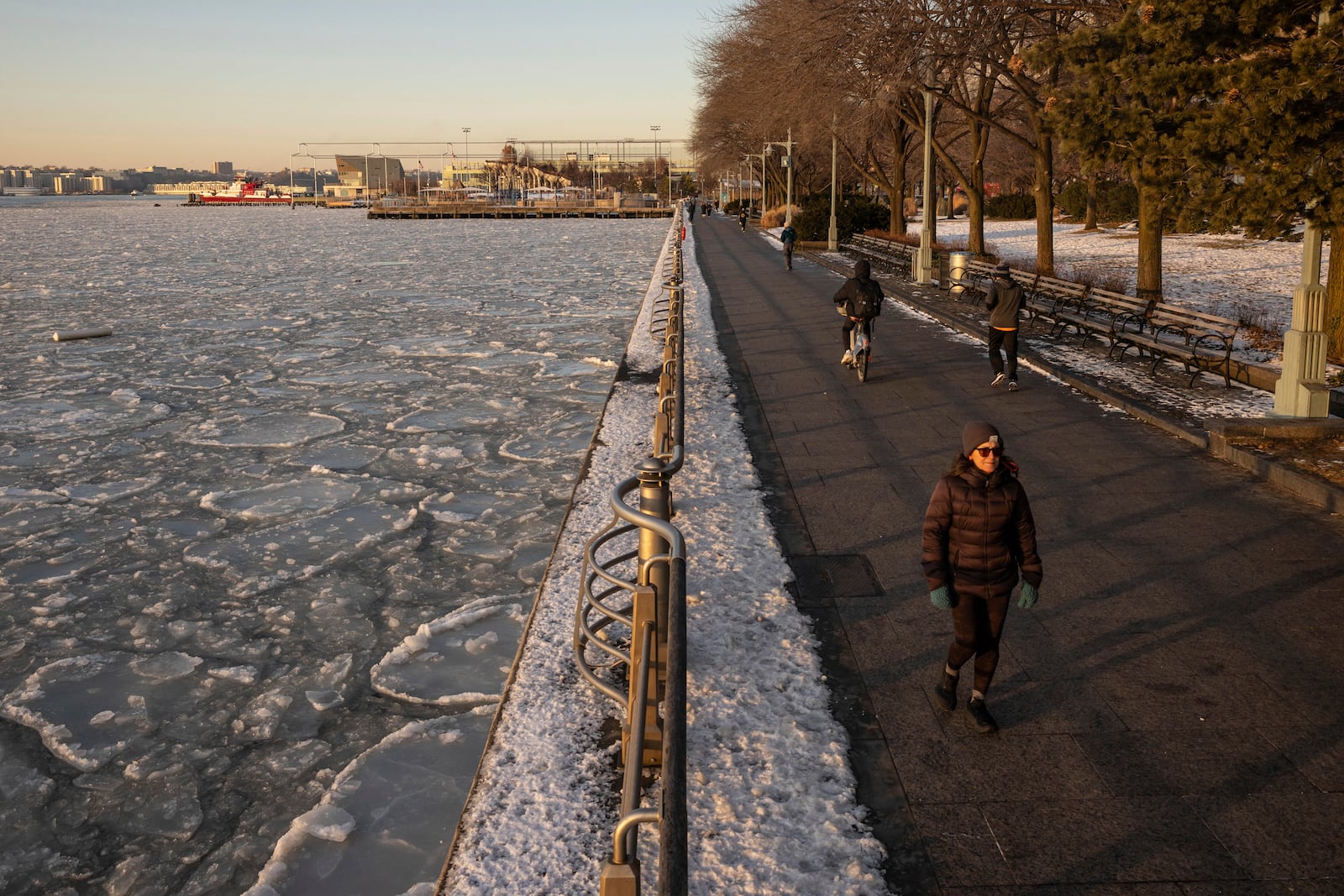 People walk along the Hudson River as it's covered by ice, Thursday, Jan. 23, 2025, in New York. (AP Photo/Yuki Iwamura)