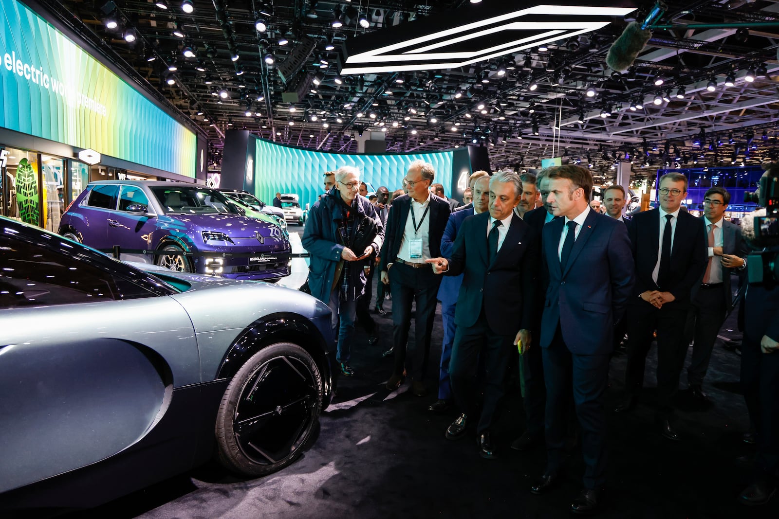 French President Emmanuel Macron, center, right, speaks with Renault general manager Luca De Meo as he visits the Renault stand at the Paris Auto Show in Paris, Monday, Oct. 14, 2024. (Ludovic Marin, Pool via AP)