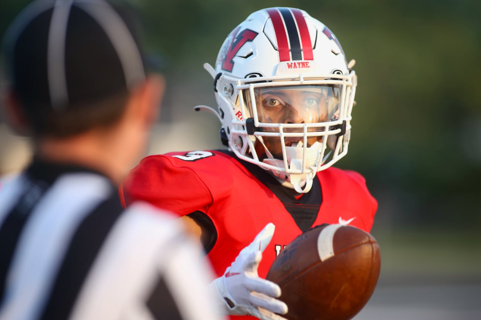 Wayne's Teaunn Hunter gives the ball back to an official after a catch against Fairfield on Friday, Aug.18, 2023, at Heidkamp Stadium in Huber Heights. David Jablonski/Staff