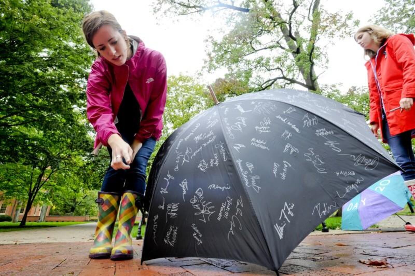 Kate Van Fossen counts signatures as she and other members of Women Against Violence and Sexual Assault try to get signatures on an umbrella to raise awareness for the Rape, Abuse and Incest National Network (RAINN) during RAINN Day 2012 Thursday, Sept. 27, on the Miami University campus in Oxford. Staff photo by Nick Graham.