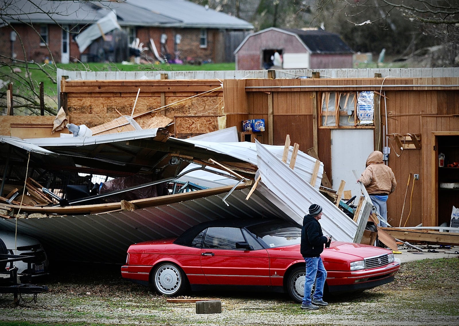 Miami County homeowners surveyed damage around their property along Klinger Road between Bradford and Covington early Friday morning March 15, 2024. MARSHALL GORBY \STAFF