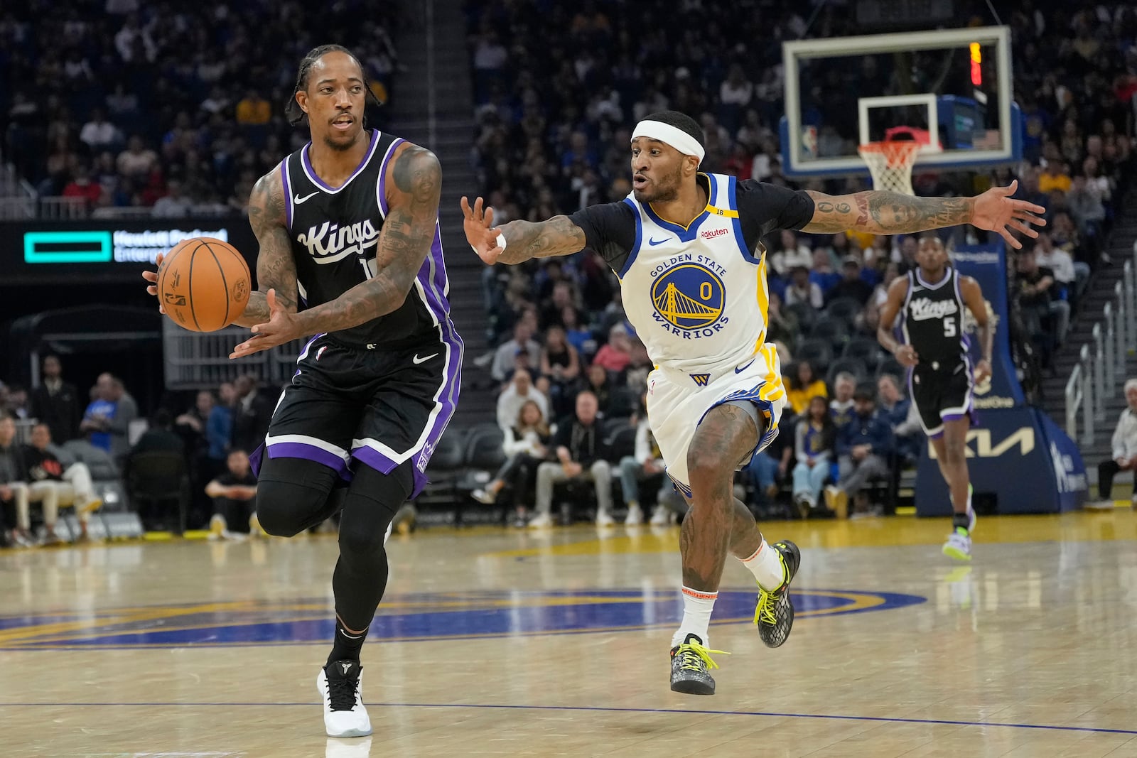 Sacramento Kings forward DeMar DeRozan, left, brings the ball up the court against Golden State Warriors guard Gary Payton II during the first half of an NBA preseason basketball game in San Francisco, Friday, Oct. 11, 2024. (AP Photo/Jeff Chiu)