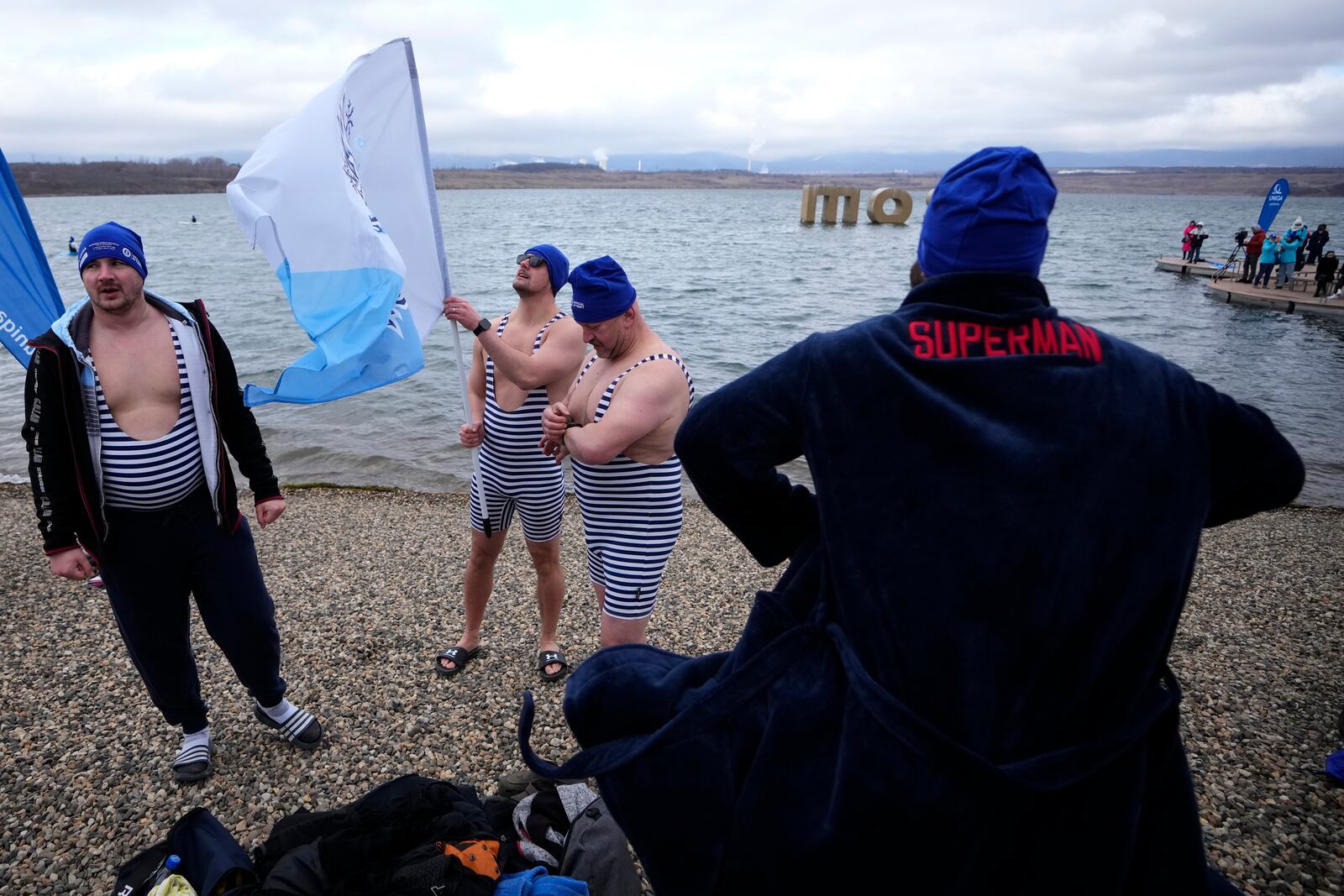 Some of 2461 polar swimmers prepare to get in the water to set a world record for the largest polar bear dip at a lake in Most, Czech Republic, Saturday, March 1, 2025. (AP Photo/Petr David Josek)