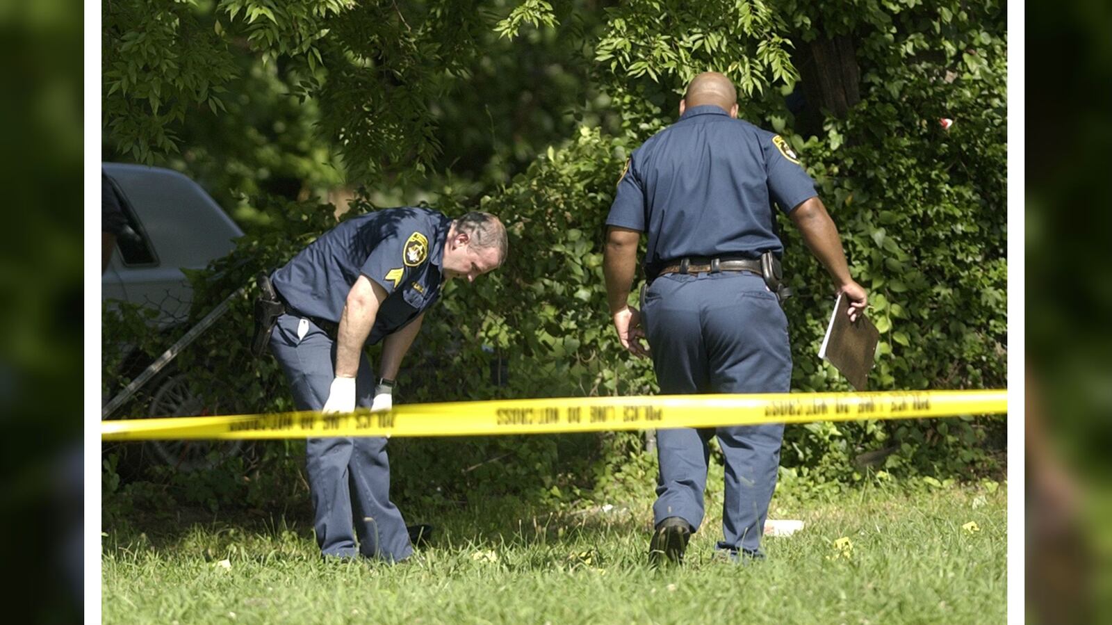 Police officers search for evidence following a shooting that killed three police officers June 17, 2004, in Birmingham, Ala. Officers Harley Alfred Chisholm III, Carlos Winston Owen and Charles Robert Bennett were gunned down as they attempted to serve a misdemeanor arrest warrant in the Ensley community of the city.