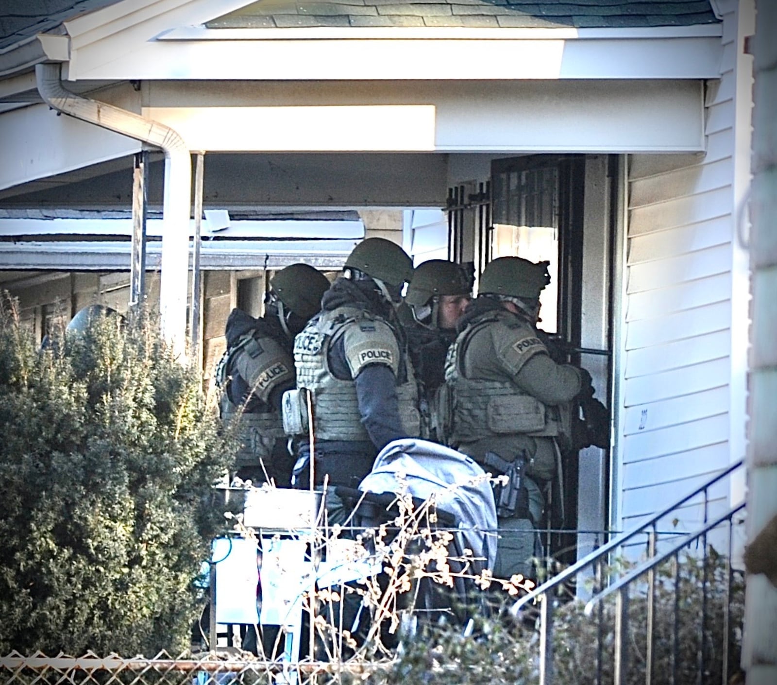 SWAT officers prepare to enter a house on Anna Street in Dayton on Wednesday, Jan. 26, 2022. Teens in the house were arrested. MARSHALL GORBY / STAFF