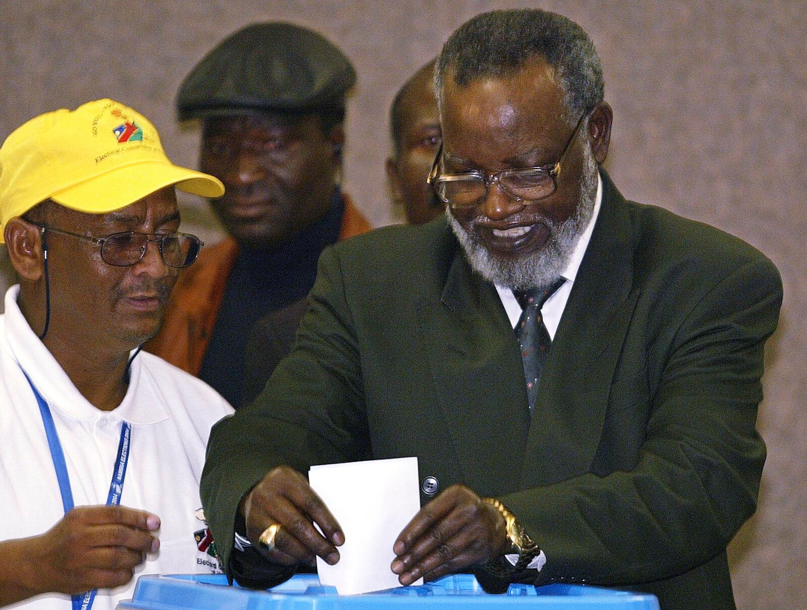 FILE - Namibian President Sam Nujoma, right, casts his vote as an unidentified election worker looks on during the Day 1 of the 2004 elections in Windhoek, Namibia, Nov. 15, 2004. (AP Photo/Themba Hadebe, File)