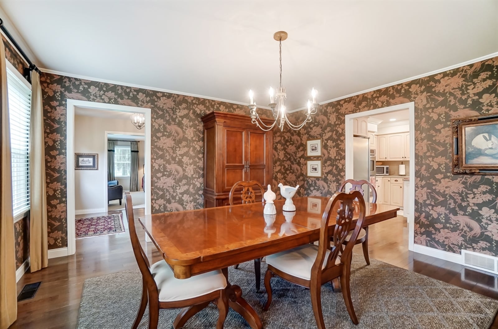 The dining room has a chandelier and front-facing windows.