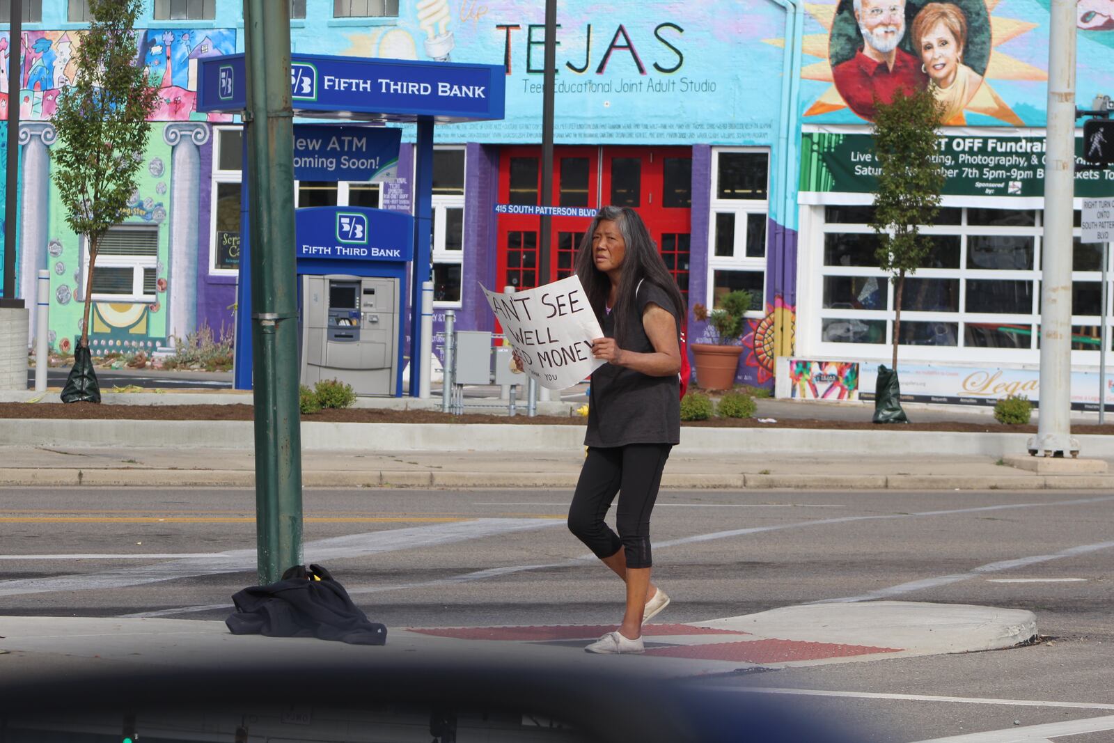 A woman downtown holds a sign that read "Can't see well. Need money. Thank you." CORNELIUS FROLIK / STAFF