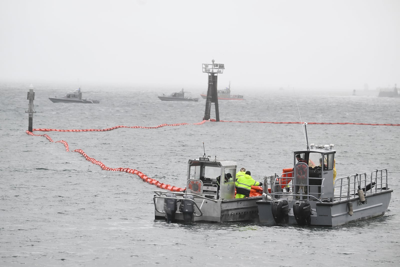 U.S. Navy boats work along the shore near Shelter Island after a U.S. Navy plane crashed into the San Diego Bay, Wednesday, Feb. 12, 2025, in San Diego. (AP Photo/Denis Poroy)