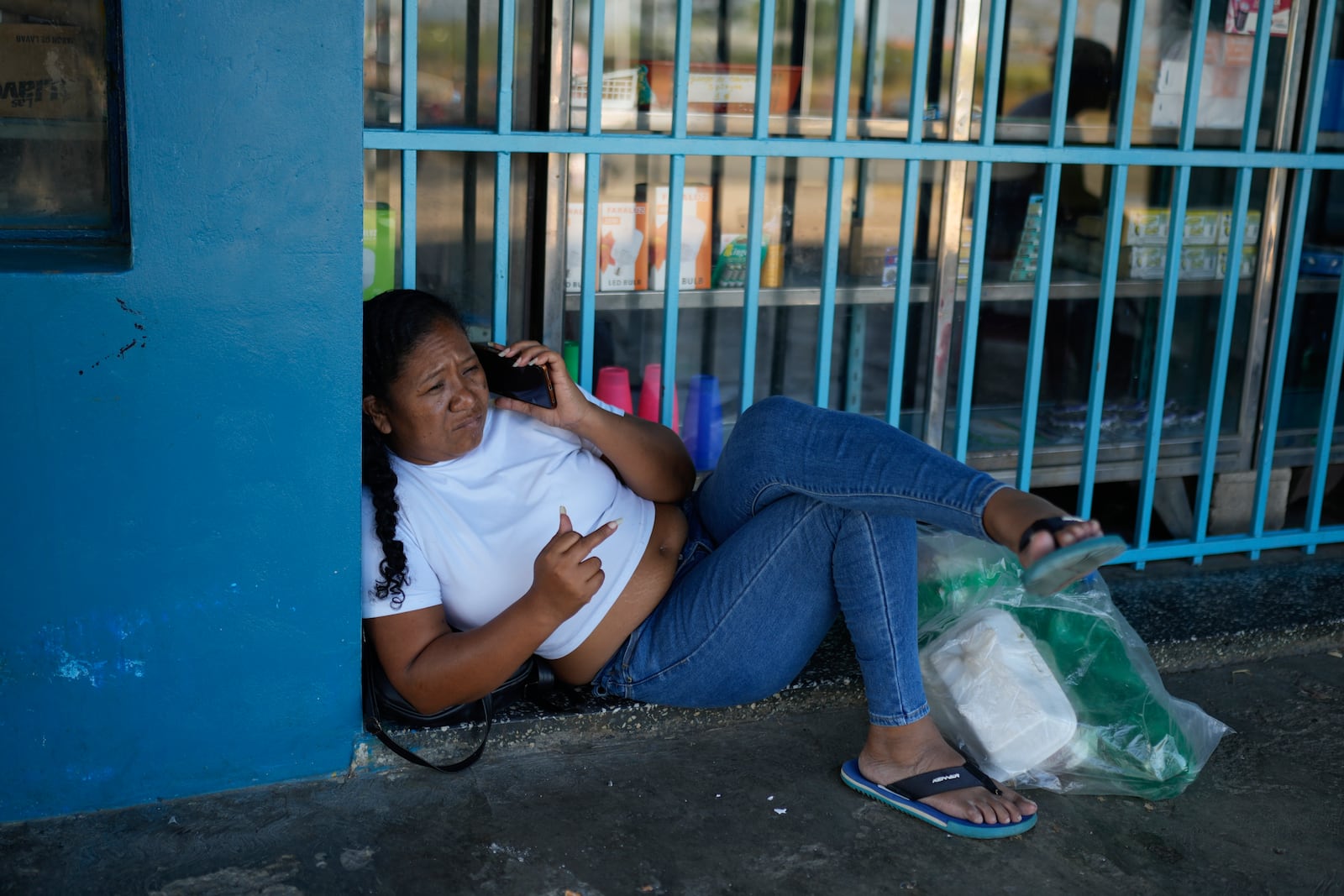 A relative of a prisoner detained in a post-election crackdown talks on the phone after visiting Tocuyito Prison in Tocuyito, Venezuela, Monday, Jan. 20, 2025. (AP Photo/Ariana Cubillos)