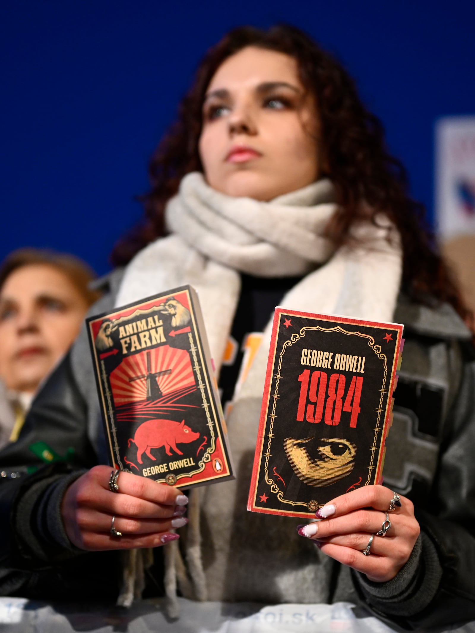 A woman holds books as thousands gather to oppose the policies of Slovakia's Prime Minister Robert Fico in Bratislava, Slovakia, Friday, Jan. 24, 2025. (AP Photo/Denes Erdos)