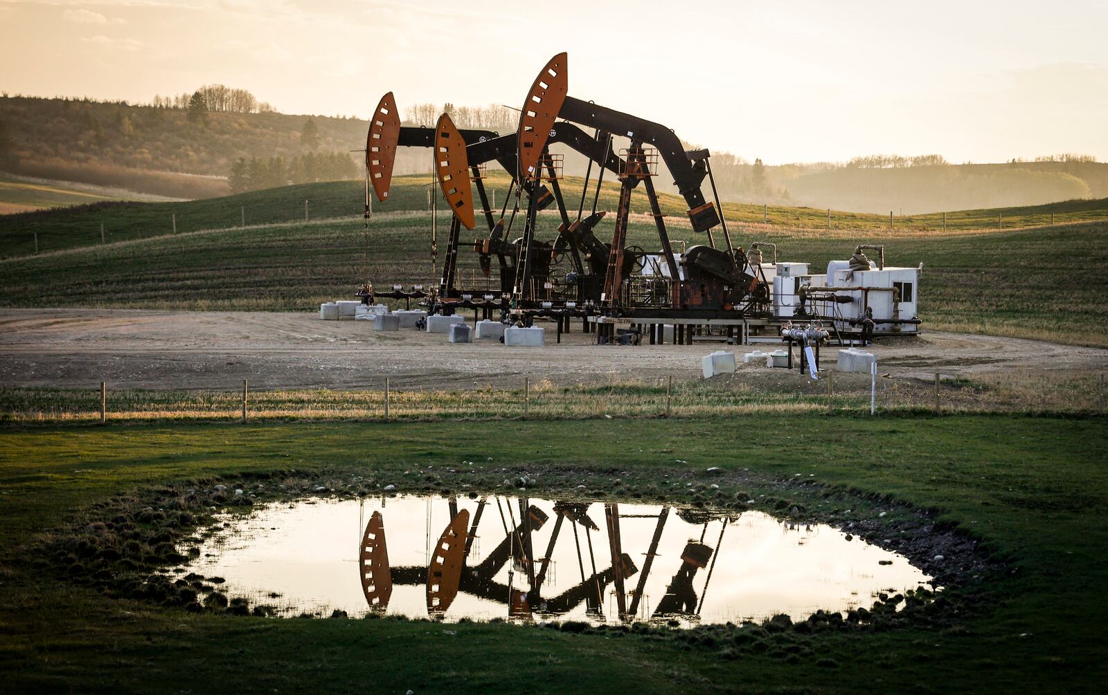 FILE - Pumpjacks draw out oil and gas from well heads as wildfire smoke hangs in the air near Calgary, Alberta, Sunday, May 12, 2024. (Jeff McIntosh/The Canadian Press via AP, File)