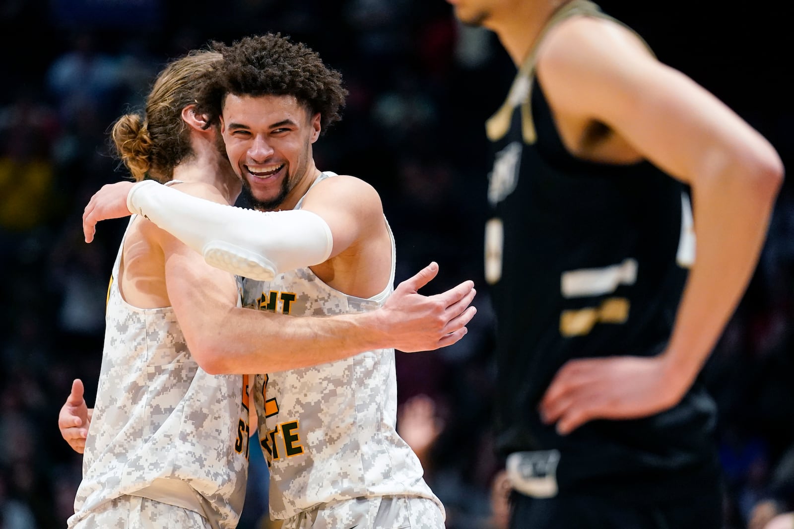 Wright State's Tanner Holden, center right, embraces Tim Finke during a game stoppage in the final second of the second half of a First Four game against Bryant in the NCAA men's college basketball tournament against Bryant, Wednesday, March 16, 2022, in Dayton, Ohio. (AP Photo/Jeff Dean)