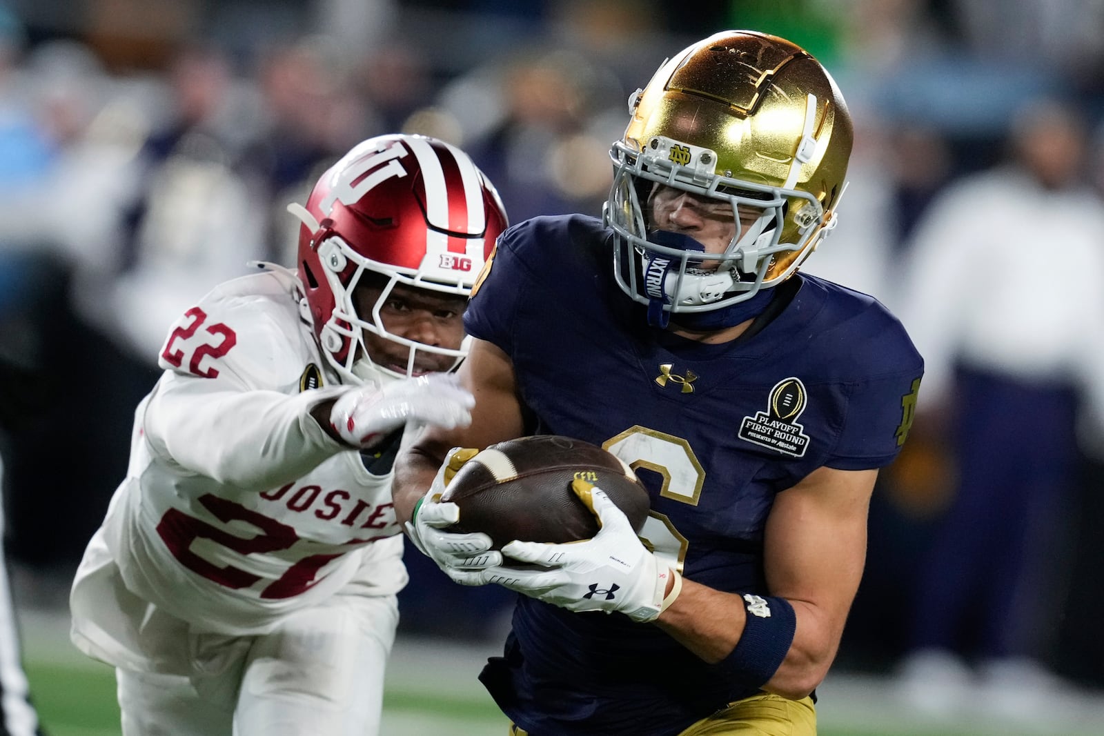 Notre Dame wide receiver Jordan Faison (6) catches a pass as Indiana defensive back Jamari Sharpe (22) defends during the second half in the first round of the NCAA College Football Playoff, Friday, Dec. 20, 2024, in South Bend, Ind. (AP Photo/Darron Cummings)