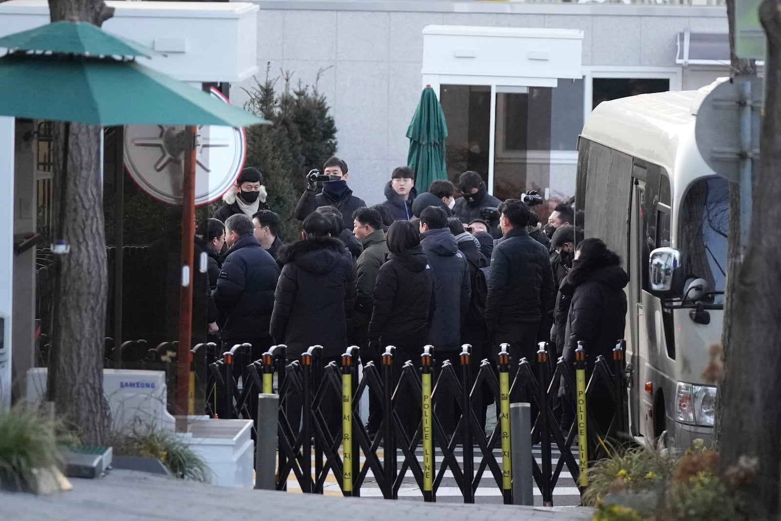 Investigators from the Corruption Investigation Office for High-ranking Officials arrive at the gate of the presidential residence as supporters of impeached South Korean President Yoon Suk Yeol stage a rally to oppose a court having issued a warrant to detain Yoon, in Seoul, South Korea, Friday, Jan. 3, 2025. (AP Photo/Lee Jin-man)