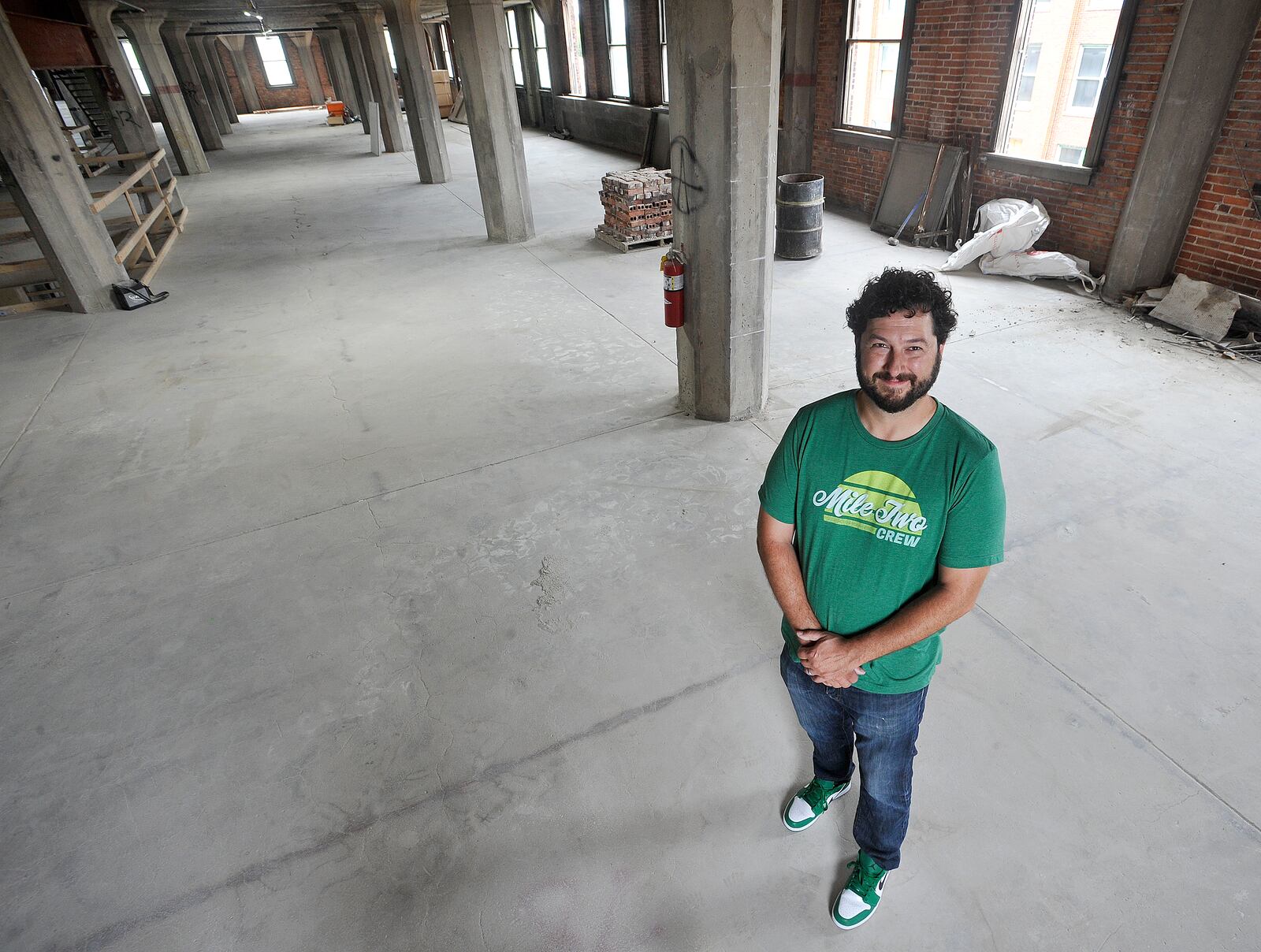 Jeff Graley, founder and CEO, of the Dayton software firm Mile Two, poses for a photo in his companies new location at the Manhattan on Third Street. MARSHALL GORBY\STAFF