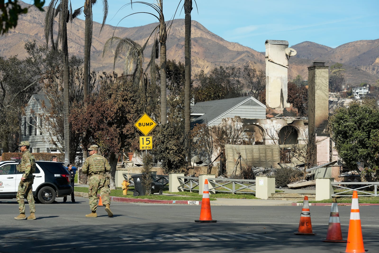 The National Guard and Los Angeles police guard a checkpoint as President Donald Trump sets to tour the Palisades Fire zone damage in the Pacific Palisades neighborhood of Los Angeles, Friday, Jan. 24, 2025. (AP Photo/Damian Dovarganes)