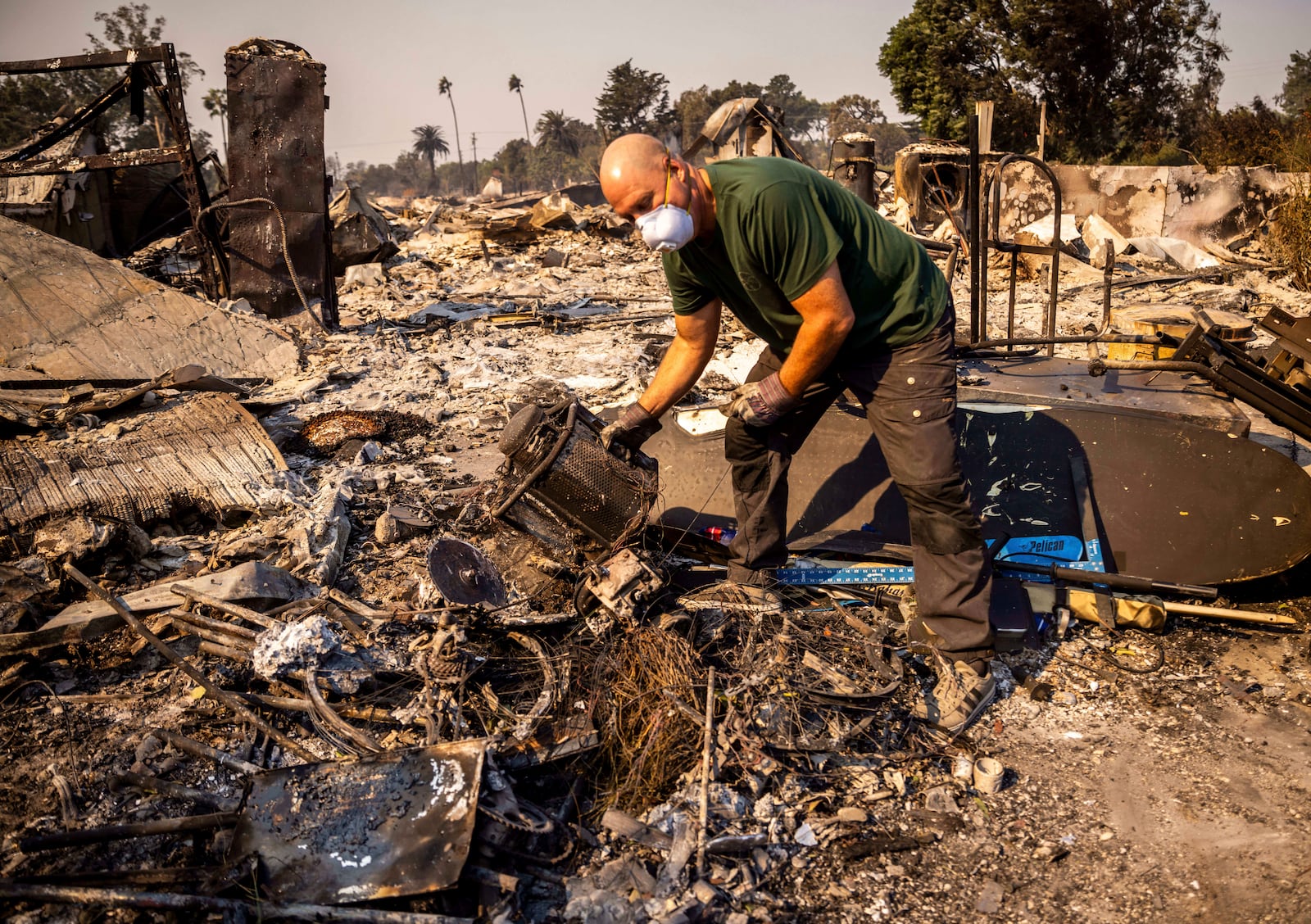 Marvin Meador sifts through his fire-ravaged property after the Mountain Fire swept through, Thursday, Nov. 7, 2024, in Camarillo, Calif. (AP Photo/Ethan Swope)