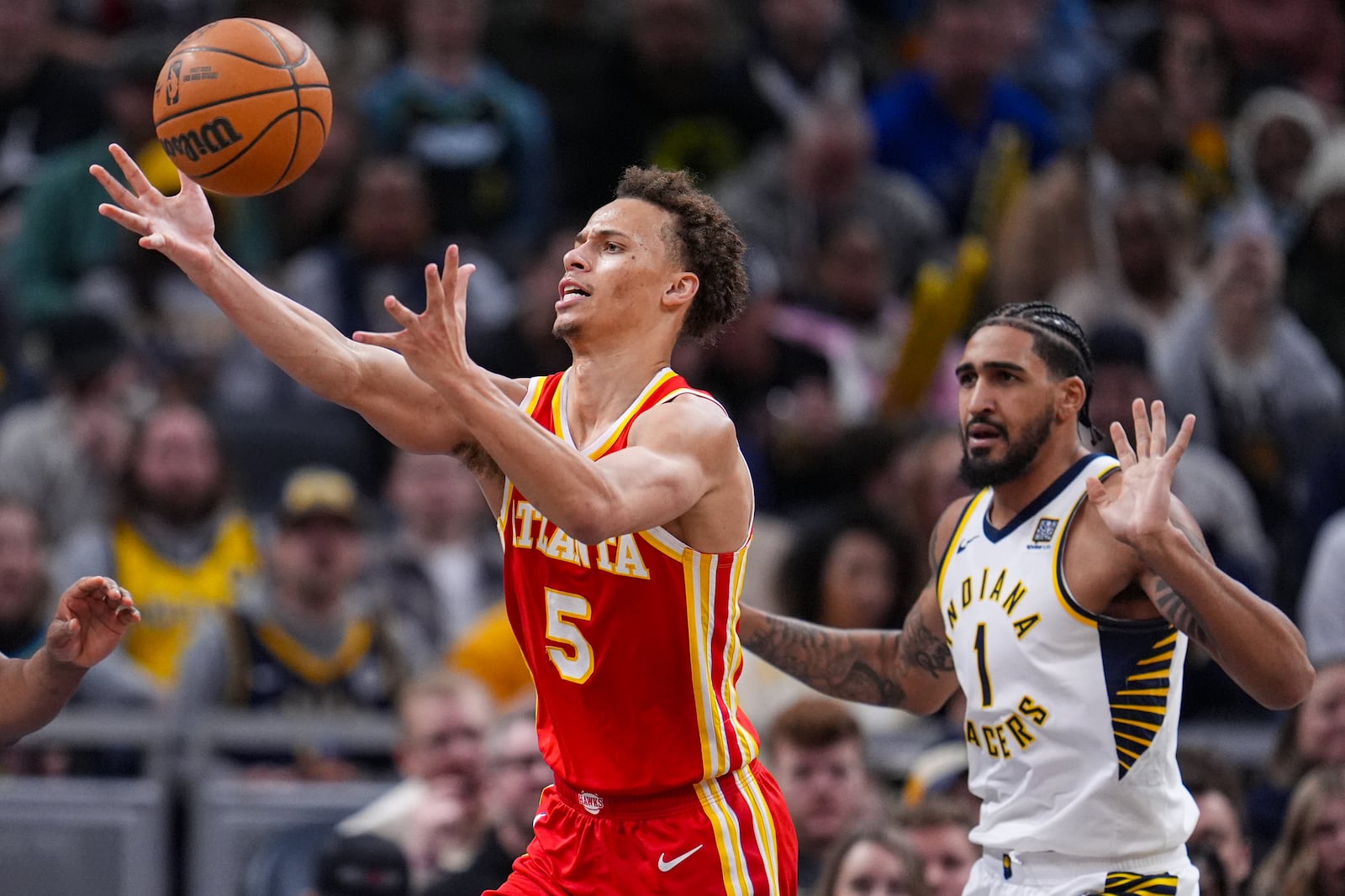 Atlanta Hawks guard Dyson Daniels (5) chases a rebound in front of Indiana Pacers forward Obi Toppin (1) during the second half of an NBA basketball game in Indianapolis, Saturday, Feb. 1, 2025. (AP Photo/Michael Conroy)