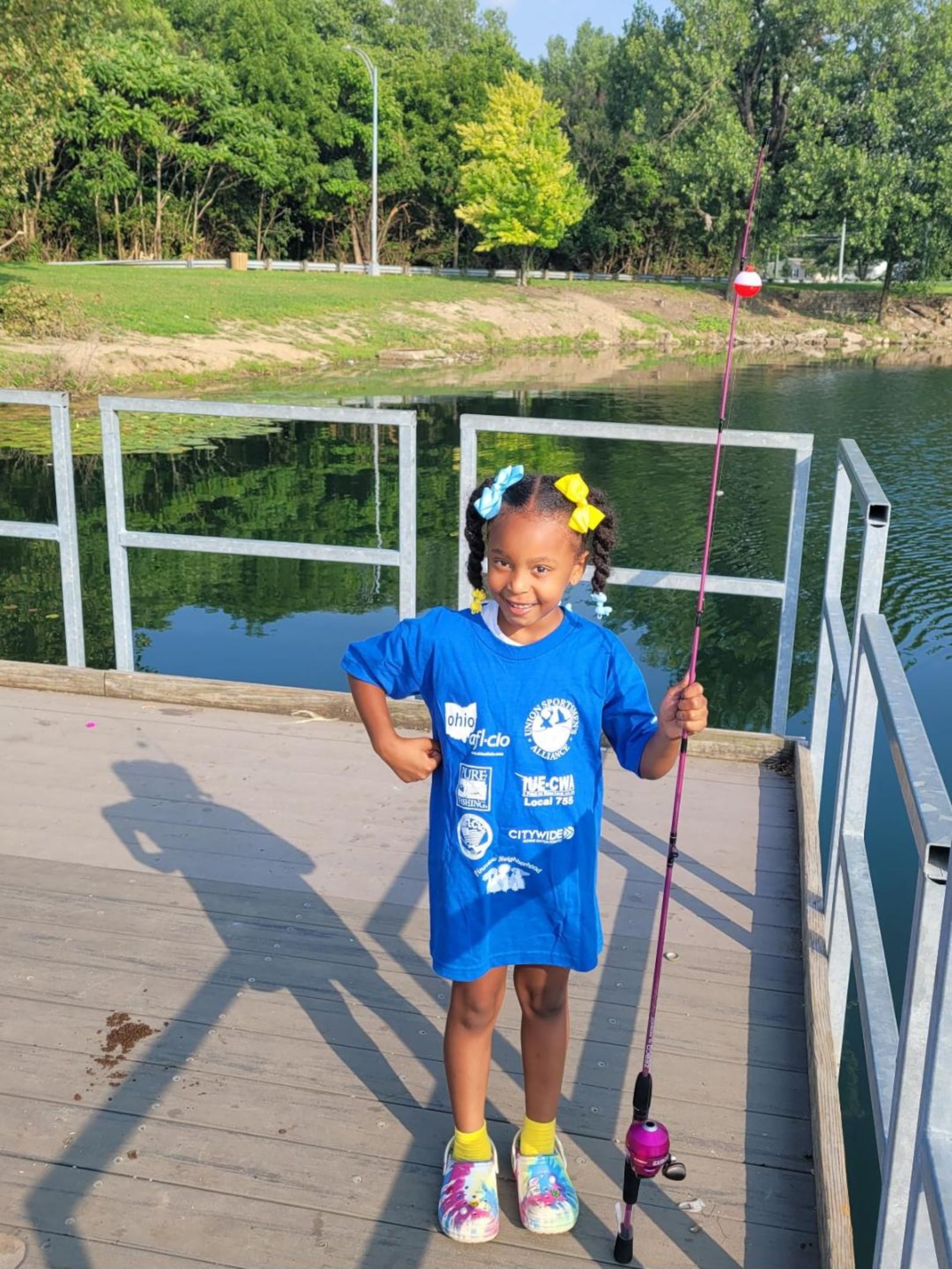 One 2023 youth attendee smiles as she gets ready to fish on the Lakeside Lake fishing pier. CONTRIBUTED