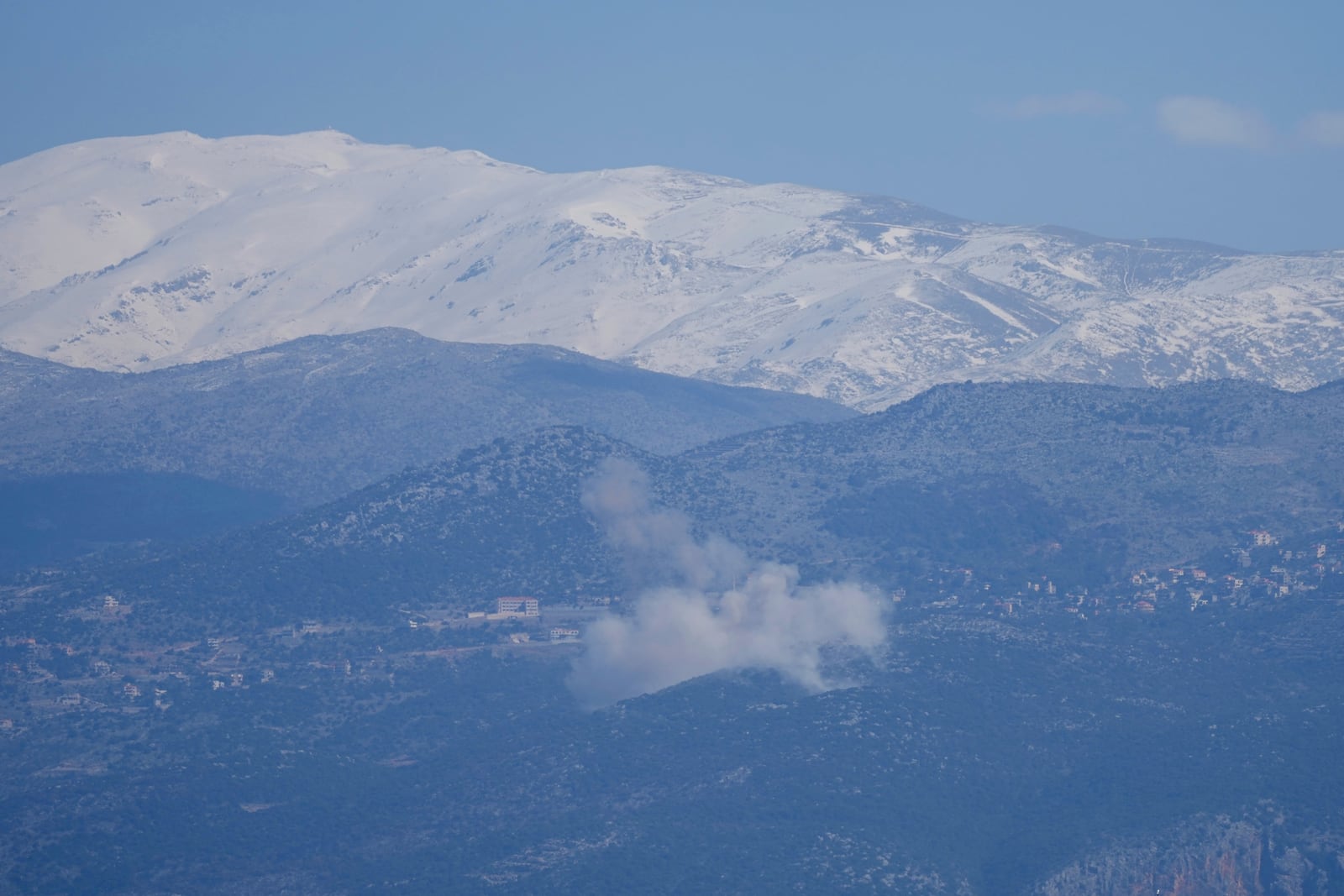 Smoke rises from an explosion in the Shebaa Farms territory, seen from the town of Kfar Kila, southern Lebanon, Tuesday, Feb. 18, 2025. (AP Photo/Hassan Ammar)