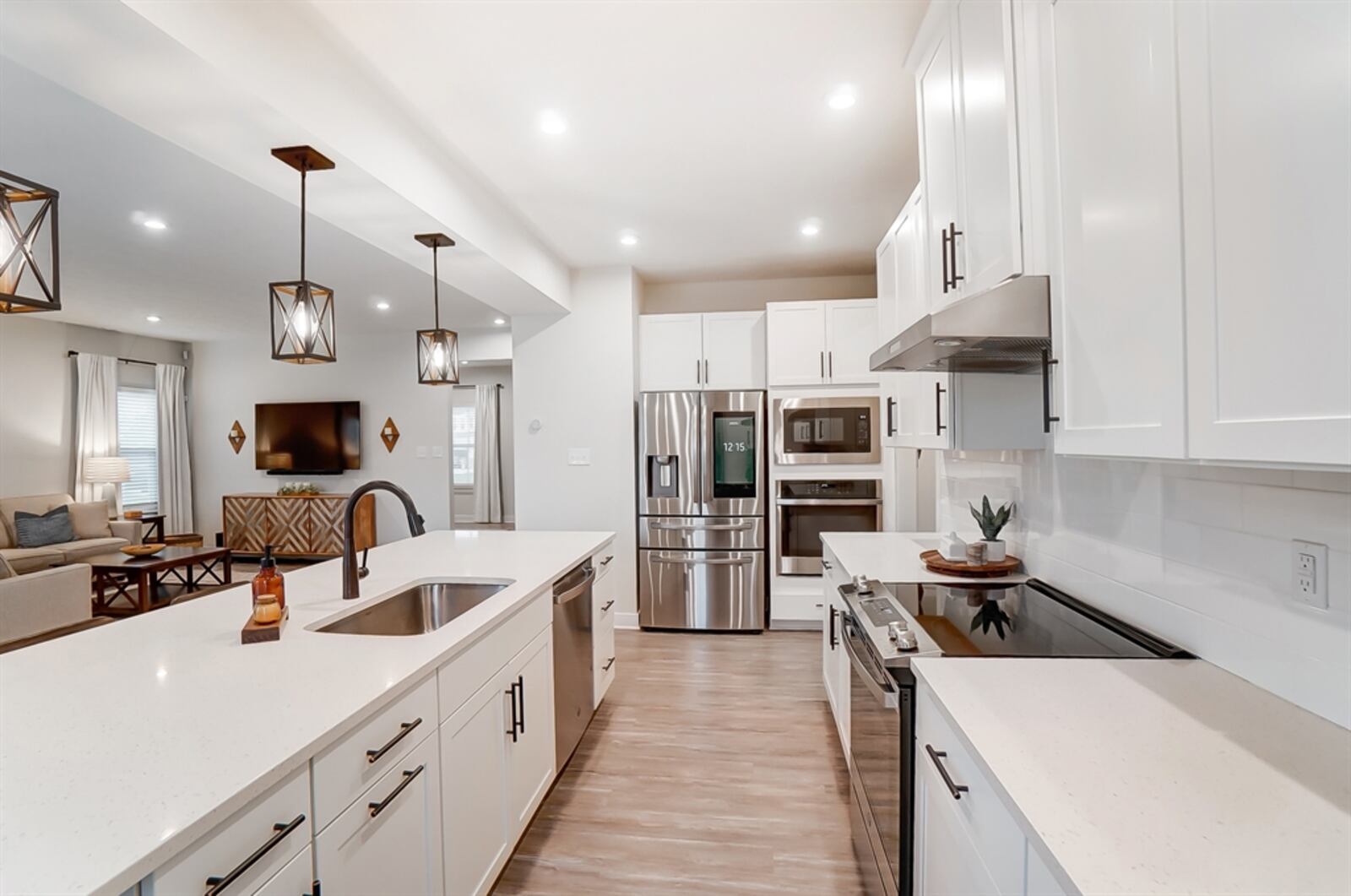 The kitchen has updated light fixtures and timeless coordinating hardware on the Shaker-style cabinetry.