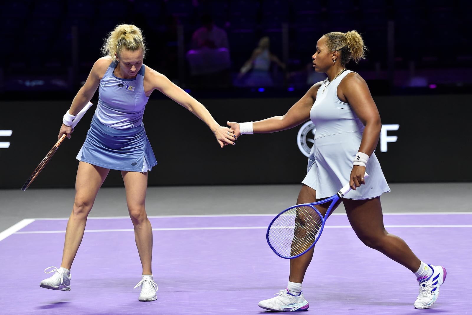 Katerina Siniakova, left, of the Czech Republic, greets Taylor Townsend of the United States, right, during their women's doubles match against Taiwan's Chan Hao-ching and Russia's Veronika Kudermetova in Riyadh, Saudi Arabia, Friday, Nov. 8, 2024. (AP Photo)