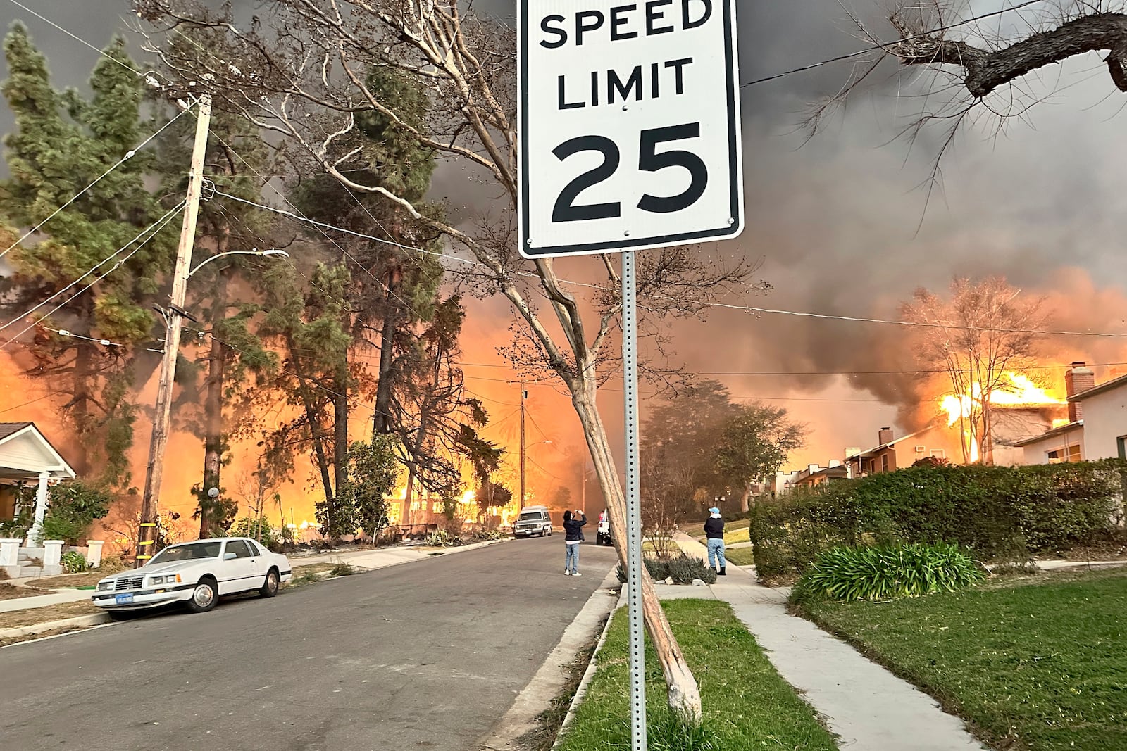 The Eaton Fire burns homes as Ryan Pearson, a Los Angeles-based entertainment video editor for The Associated Press, drives through his neighborhood in Altadena, Calif., Wednesday, Jan. 8, 2025. (AP Photo/Ryan Pearson)