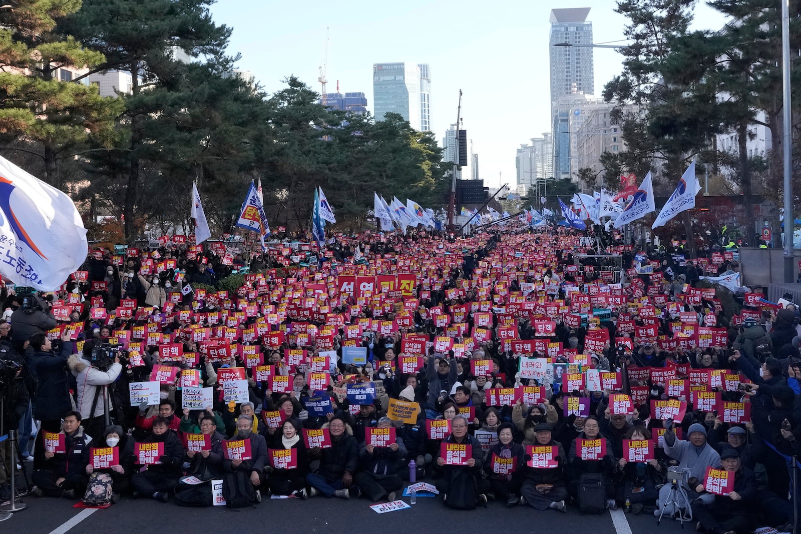 Protesters stage a rally demanding South Korean President Yoon Suk Yeol's impeachment, in front of the National Assembly in Seoul, South Korea, Saturday, Dec. 7, 2024, following the president's short-lived martial law declaration. The signs read, "Impeach Yoon Suk Yeol." (AP Photo/Ahn Young-joon)