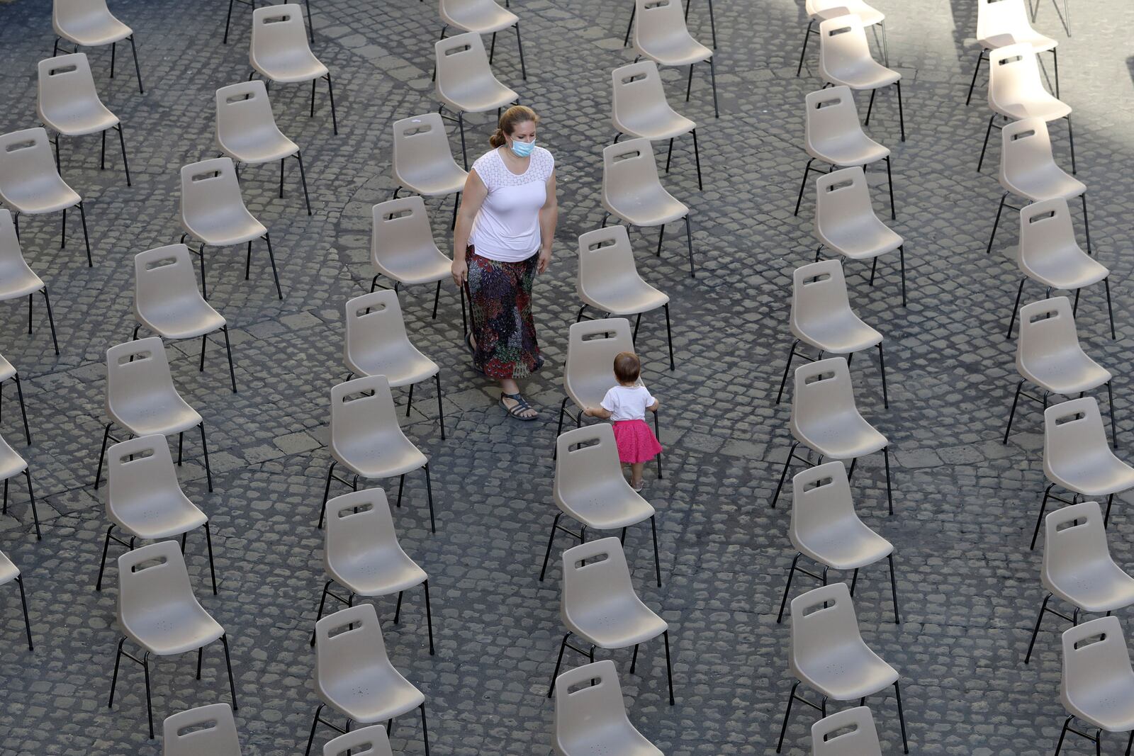 A child plays among empty chairs prior to Pope Francis weekly general audience in San Damaso courtyard at the Vatican, Wednesday, Sept. 9, 2020. (AP Photo/Andrew Medichini)