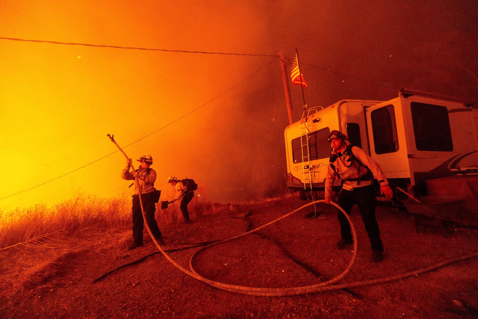 Firefighters spray water on the Hughes Fire in Castaic, Calf., Wednesday, Jan. 22, 2025. (AP Photo/Ethan Swope)