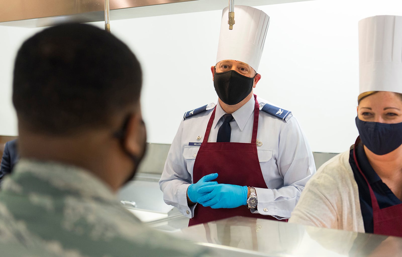 Col. Patrick Miller (center) 88th Air Base Wing and installation commander, and his wife, Beth, chat with Airman 1st Class Dantaydin Mitchell, 88th Medical Support Squadron, on Nov. 19 in the dining facility at Wright-Patterson Air Force Base as they help serve Thanksgiving dinners. U.S. AIR FORCE PHOTO/R.J. ORIEZ