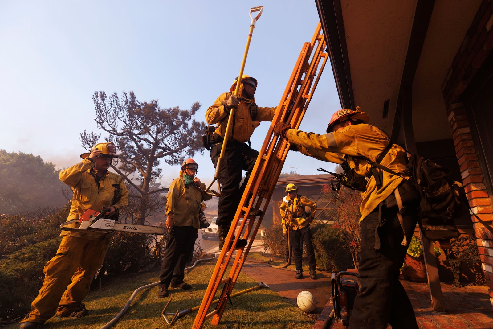 Firefighters prepare for structure protection as the Palisades Fire advances in the Pacific Palisades neighborhood of Los Angeles, Tuesday, Jan. 7, 2025. (AP Photo/Ethan Swope)