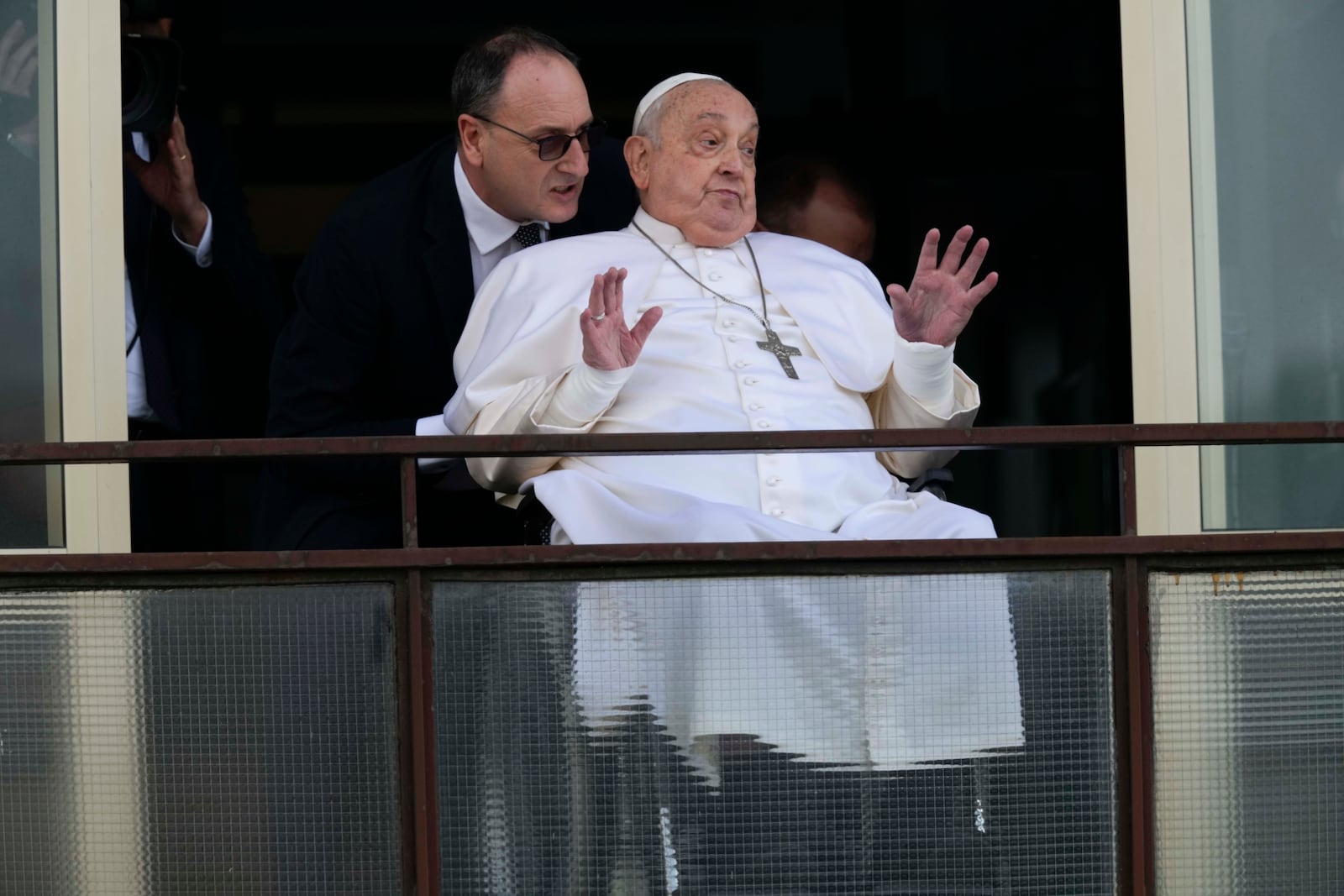 Pope Francis gestures as he appears at a window of the Agostino Gemelli Polyclinic in Rome, Sunday, March 23, 2025, where he has been treated for bronchitis and bilateral pneumonia since Feb. 14. (AP Photo/Domenico Stinellis)