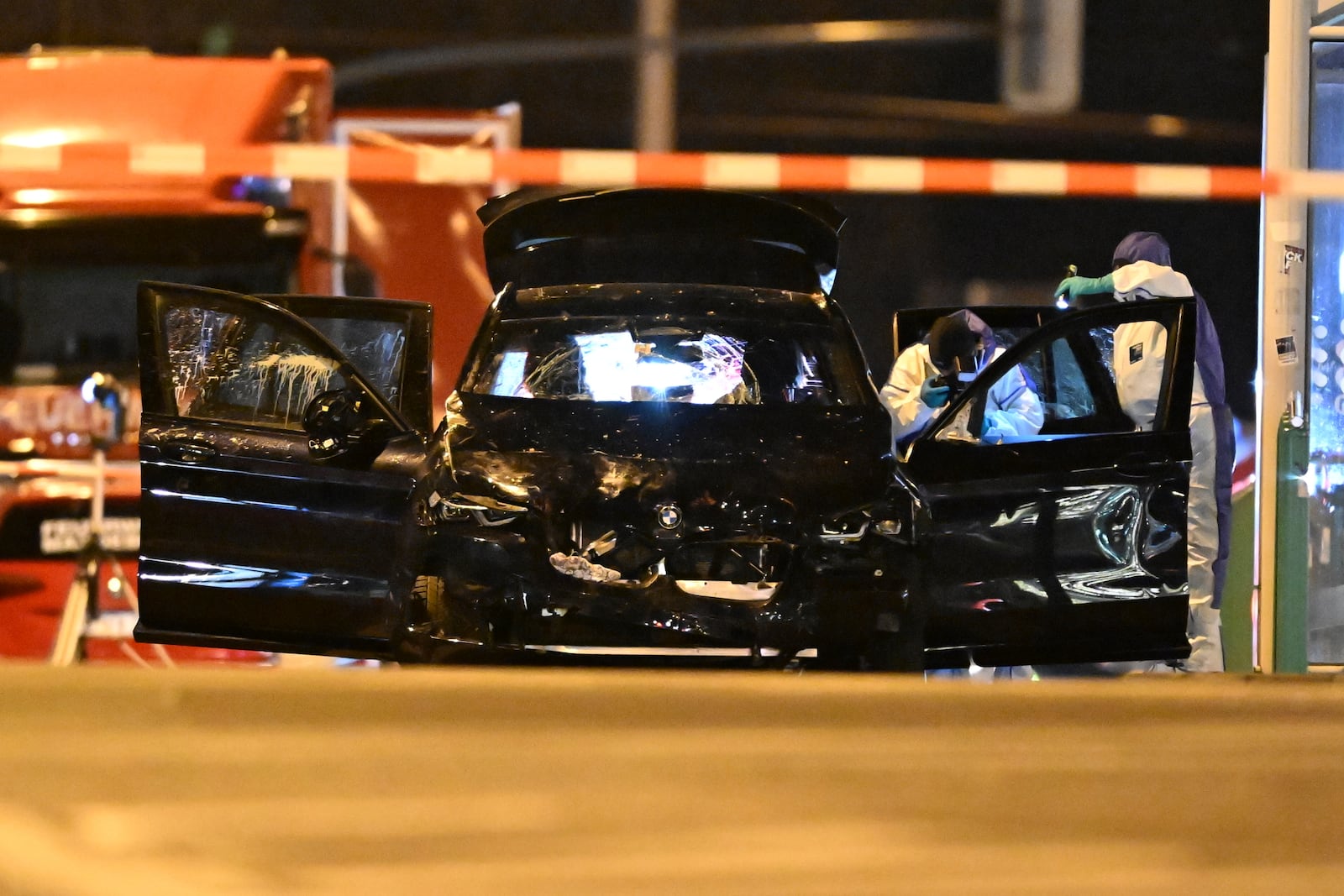 Forensics work on a damaged car sitting with its doors open after a driver plowed into a busy Christmas market in Magdeburg, Germany, early Saturday, Dec. 21, 2024. (Hendrik Schmidt/dpa via AP)