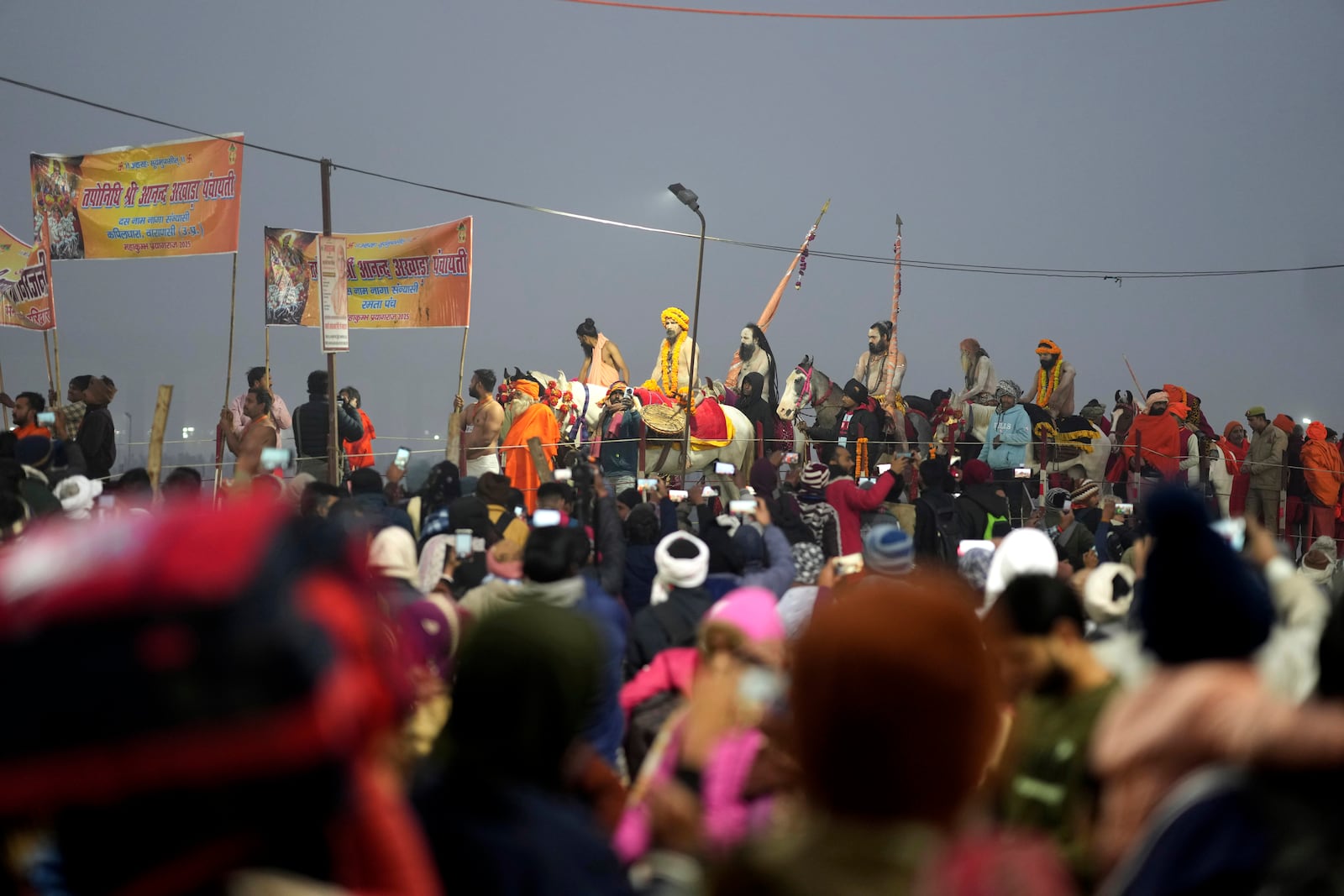 Naga Sadhus of Niranjani Akhara arrive for ritualistic dip at Sangam, the confluence of the Rivers Ganges, Yamuna and mythical Saraswati on one of the most auspicious day Makar Sankranti, for the Maha Kumbh festival in Prayagraj, India, Tuesday, Jan. 14, 2025. (AP Photo/Rajesh Kumar Singh)