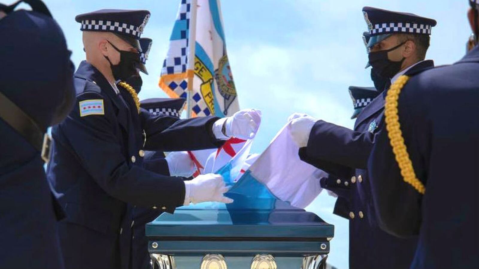 Protective gear-clad pallbearers fold the flag that was draped over the casket holding Chicago police Officer Marco DiFranco at the officer’s April 9, 2020, funeral. DiFranco, a narcotics officer, died April 2 of COVID-19, the illness caused by the novel coronavirus. (Chicago Police Department)