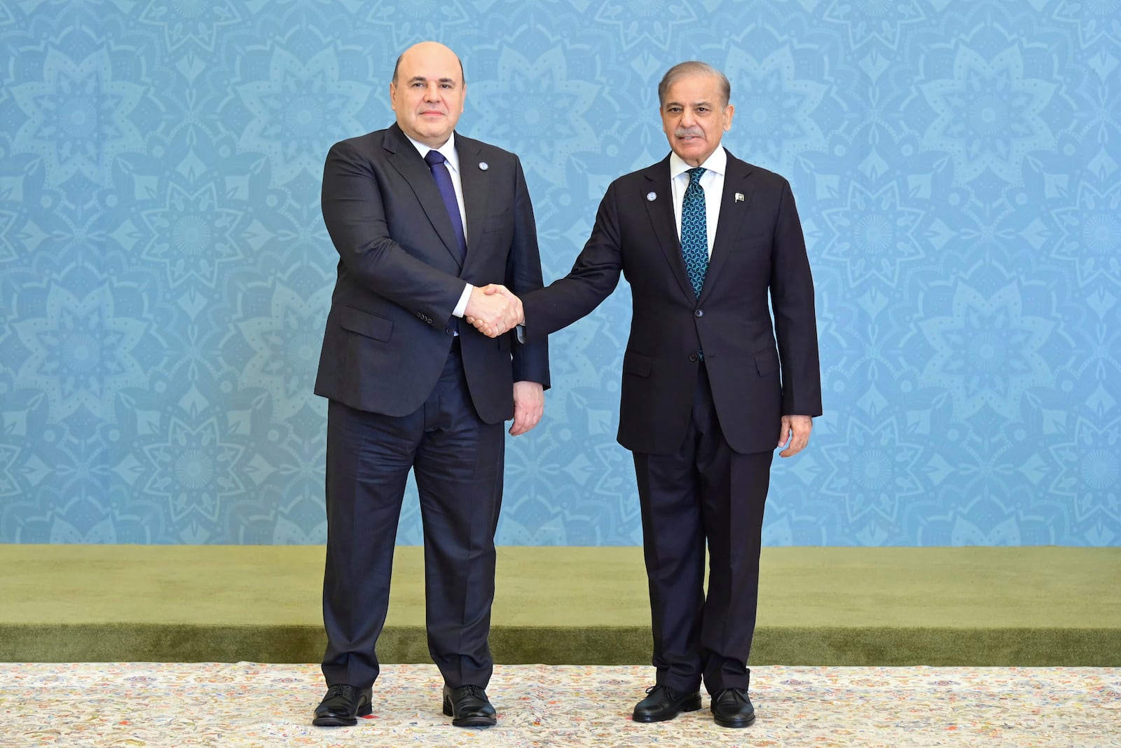 In this photo released by the Press Information Department, Russian Prime Minister Mikhail Mishustin, left, shakes hand with his Pakistani counterpart Shehbaz Sharif as he arrives to attend Shanghai Cooperation Organization (SCO) meeting, in Islamabad, Pakistan, Wednesday, Oct. 16, 2024. (Press Information Department via AP)