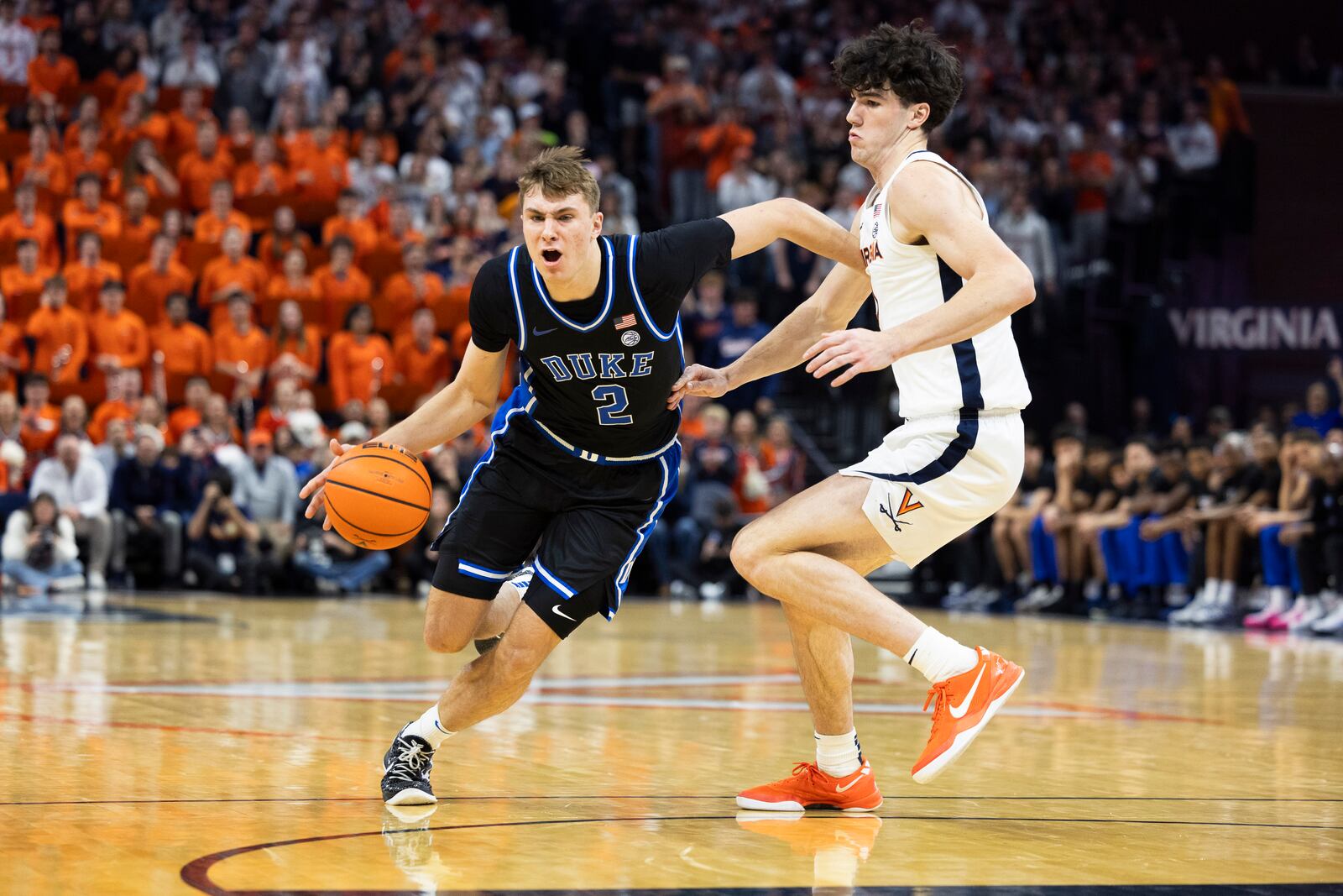 Duke guard Cooper Flagg (2) drives past Virginia forward Blake Buchanan during the first half of an NCAA college basketball game, Monday, Feb. 17, 2025, in Charlottesville, Va. (AP Photo/Mike Kropf)