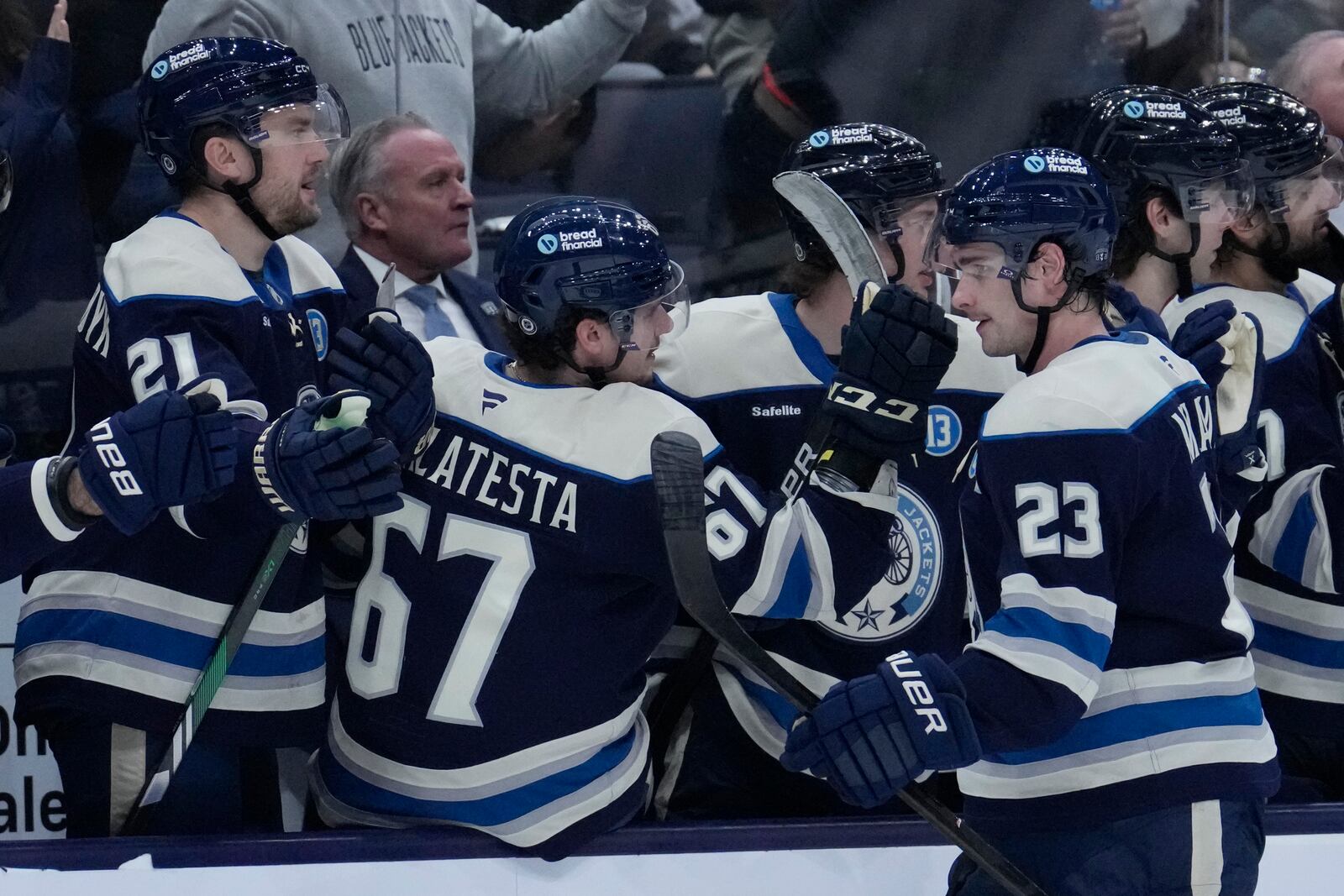 Columbus Blue Jackets center Sean Monahan (23) is congratulated by teammates after scoring in the third period of an NHL hockey game against the New Jersey Devils Thursday, Dec. 19, 2024, in Columbus, Ohio. (AP Photo/Sue Ogrocki)