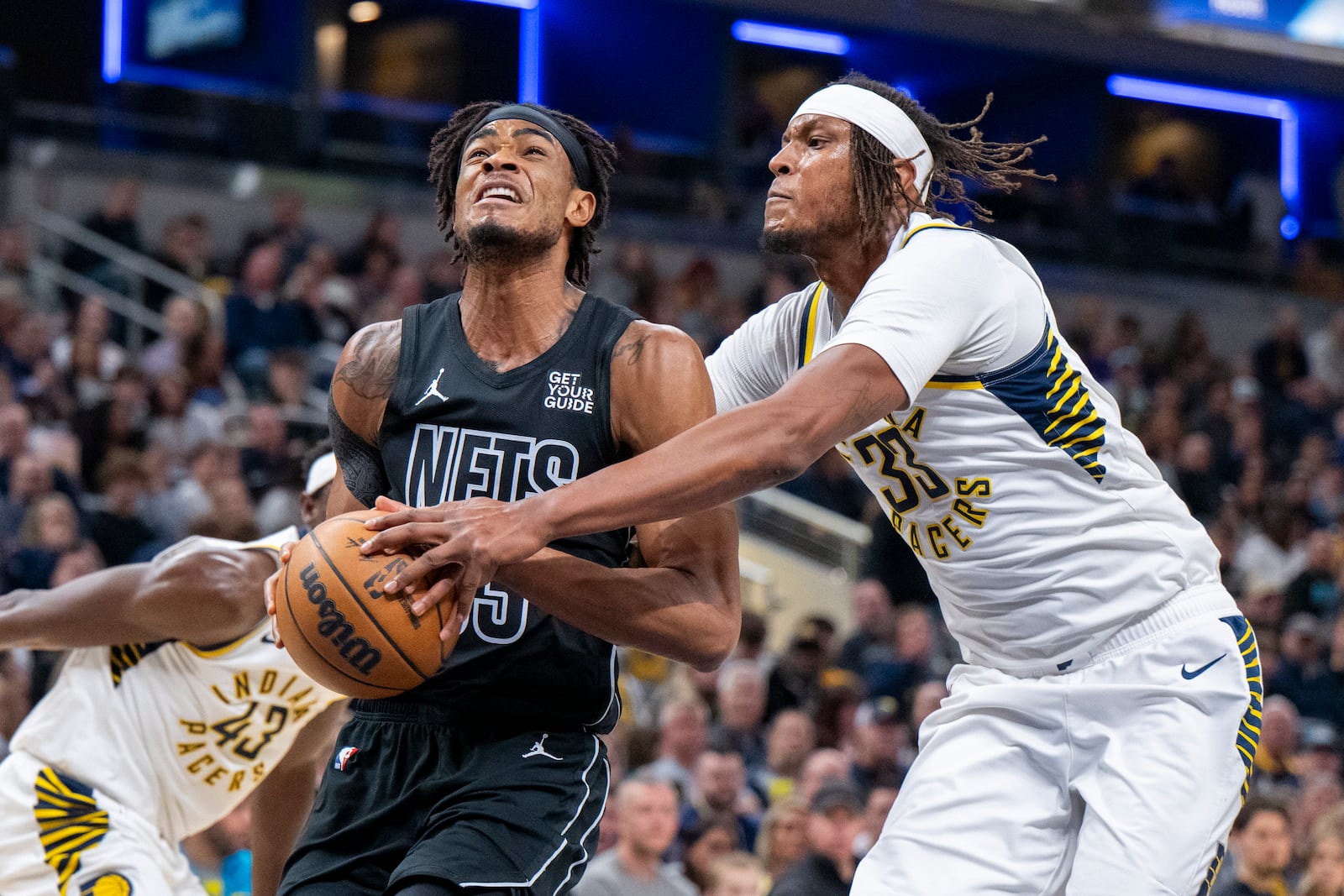 Indiana Pacers center Myles Turner (33) attempts to stop a shot by Brooklyn Nets center Nic Claxton (33) during the first half of an NBA basketball game in Indianapolis, Saturday, March 22, 2025. (AP Photo/Doug McSchooler)